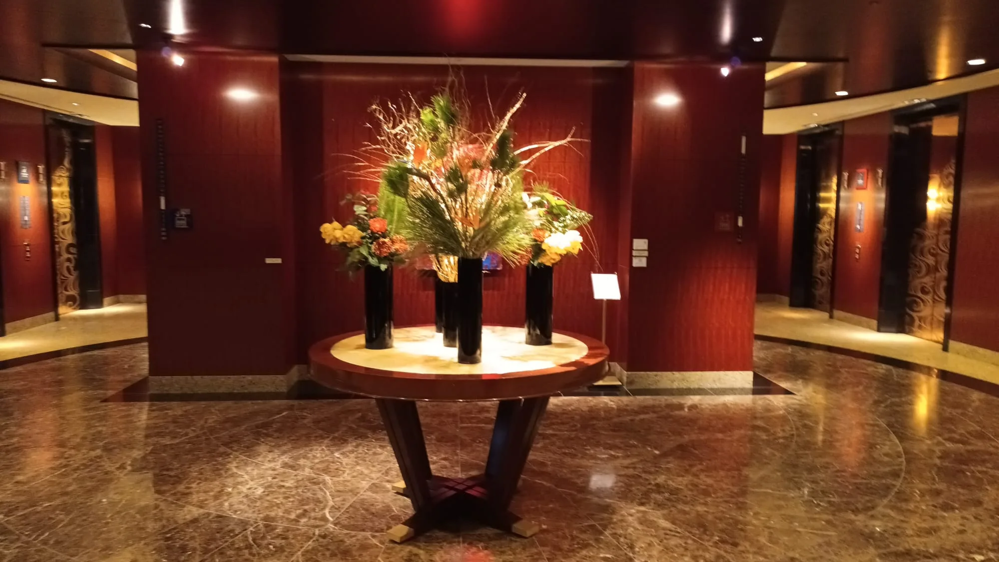 Hotellobby mit dekorativer Blumeneinrichtung auf runder Tischplatte