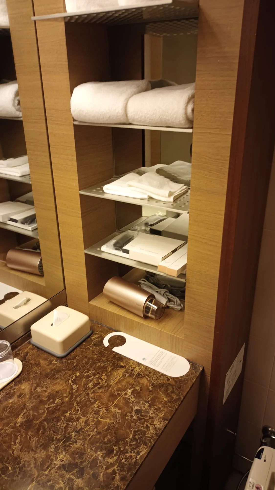 Hotelzimmerschrank mit Handtüchern und elektrischem Haartrockner