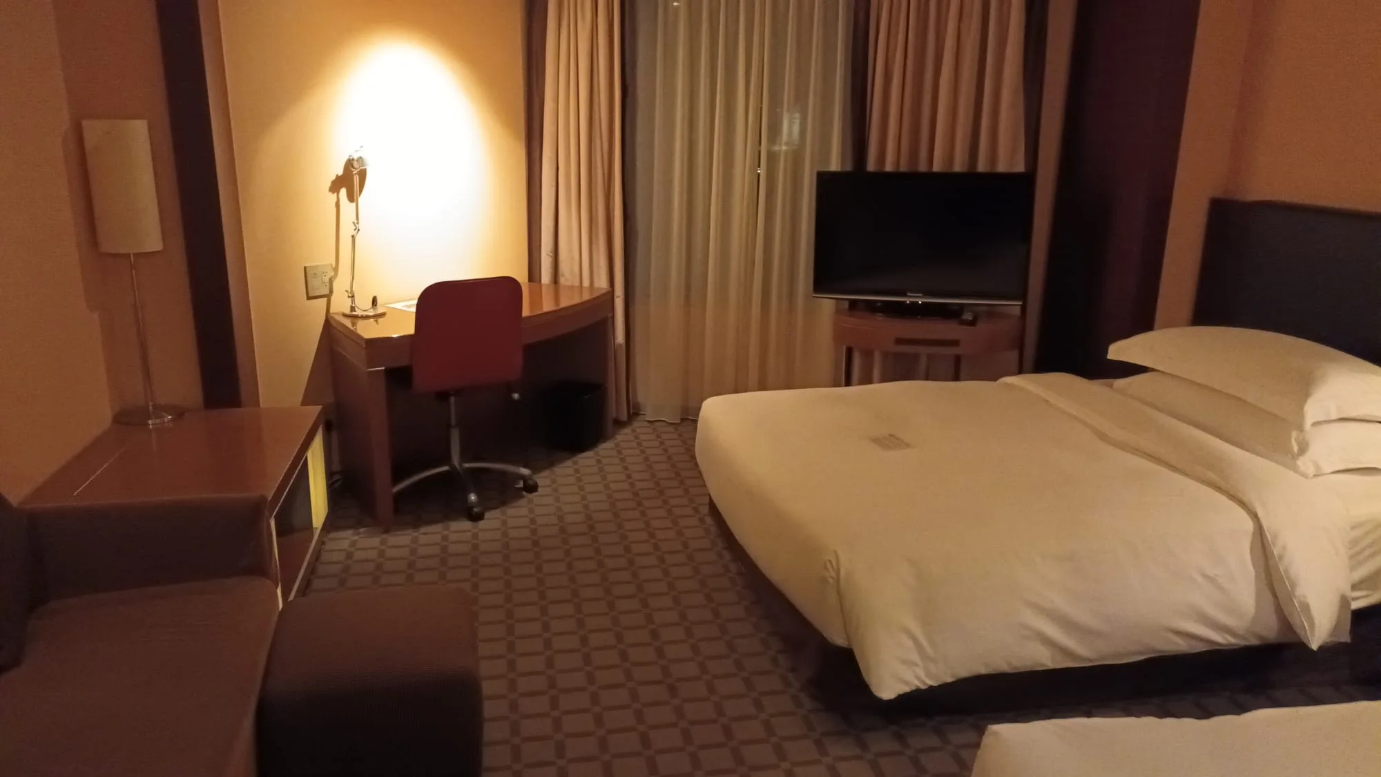Hotelzimmer mit Doppelbett und Schreibtisch
