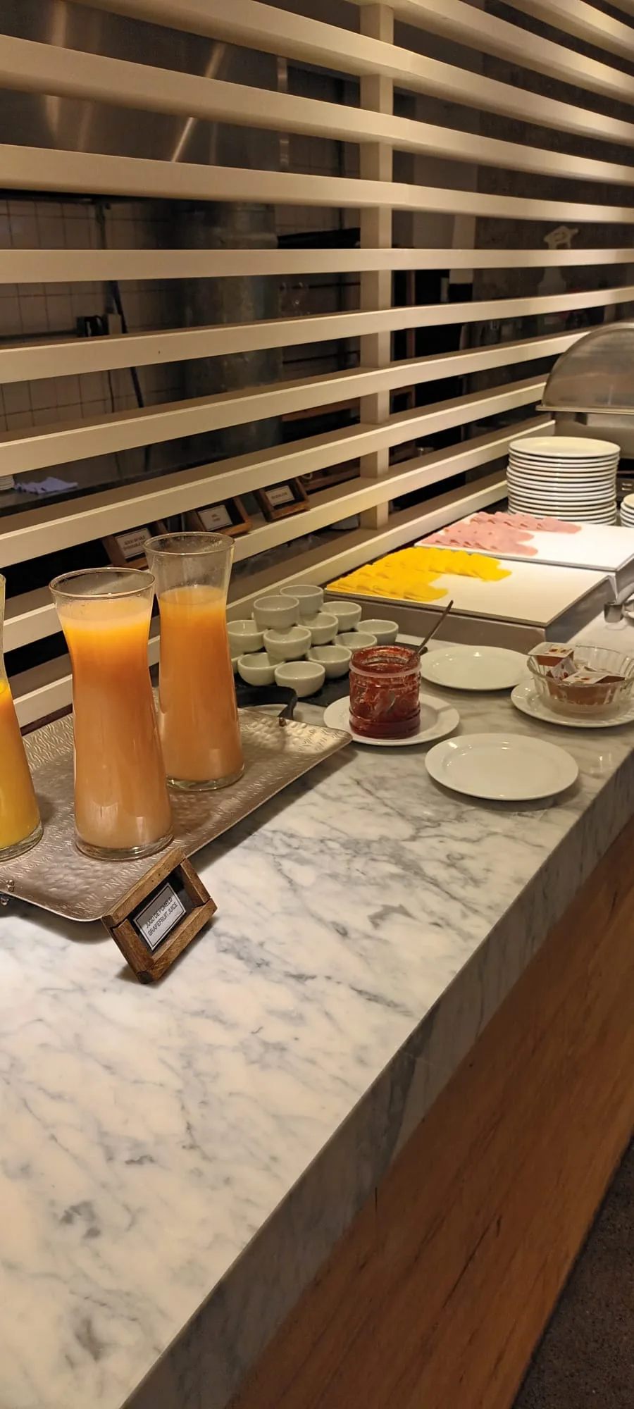 Frühstückstablett mit Saftgläsern und Frühstücksküche im Hintergrund