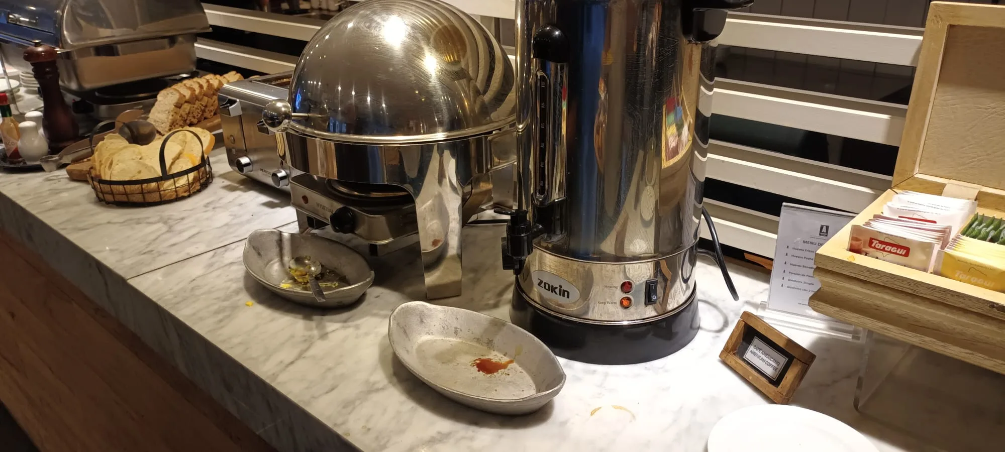 Buffet mit Kaffeemaschine und Schüsseln auf Marmorplatte