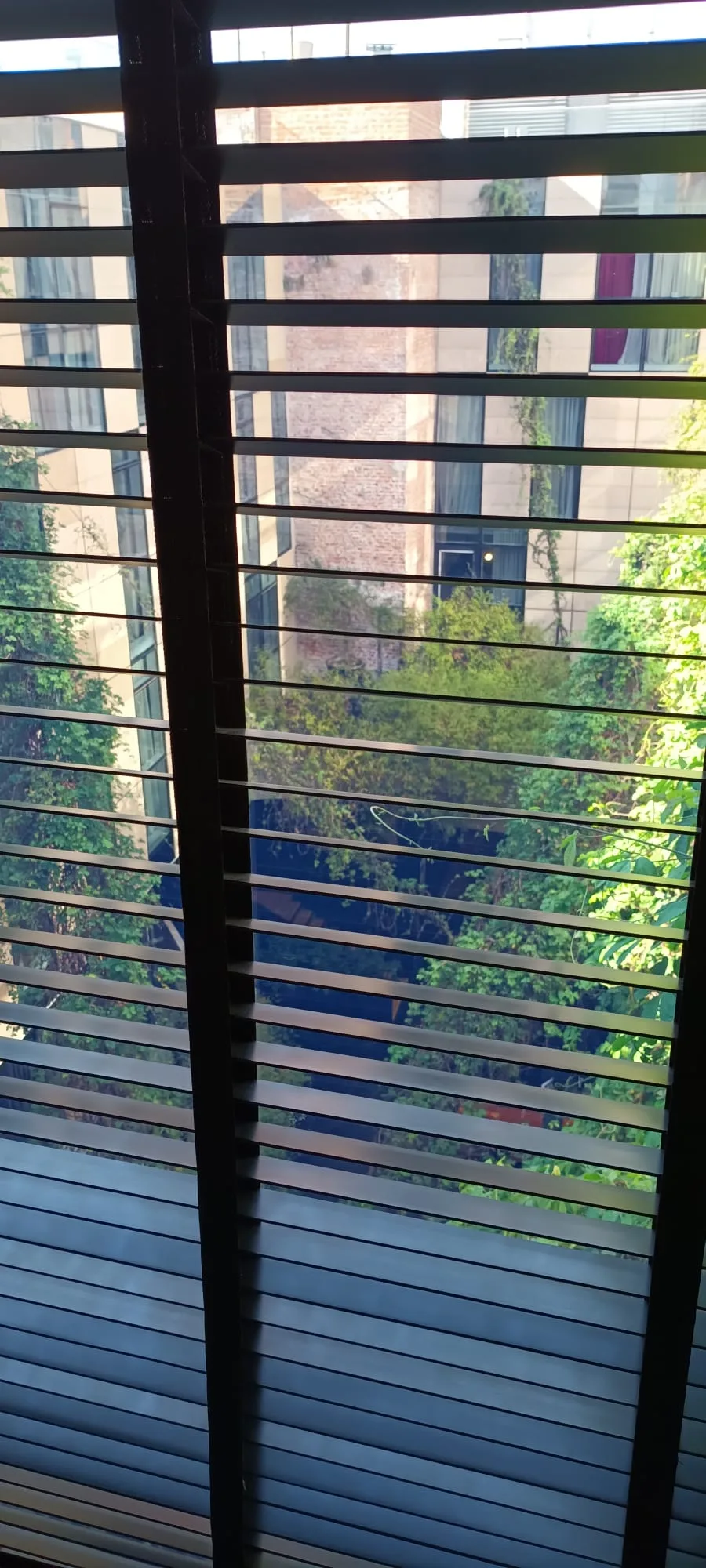 Fensterblick auf Hochhaus mit Jalousien
