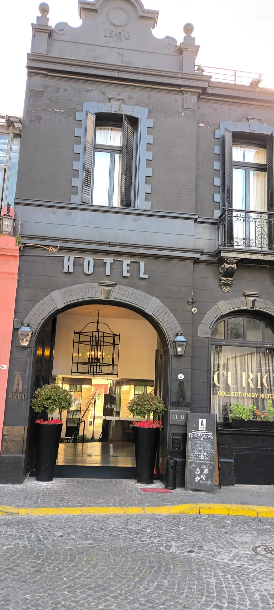 Hotelgebäude mit Eingangsbereich und Pflanzen vorne