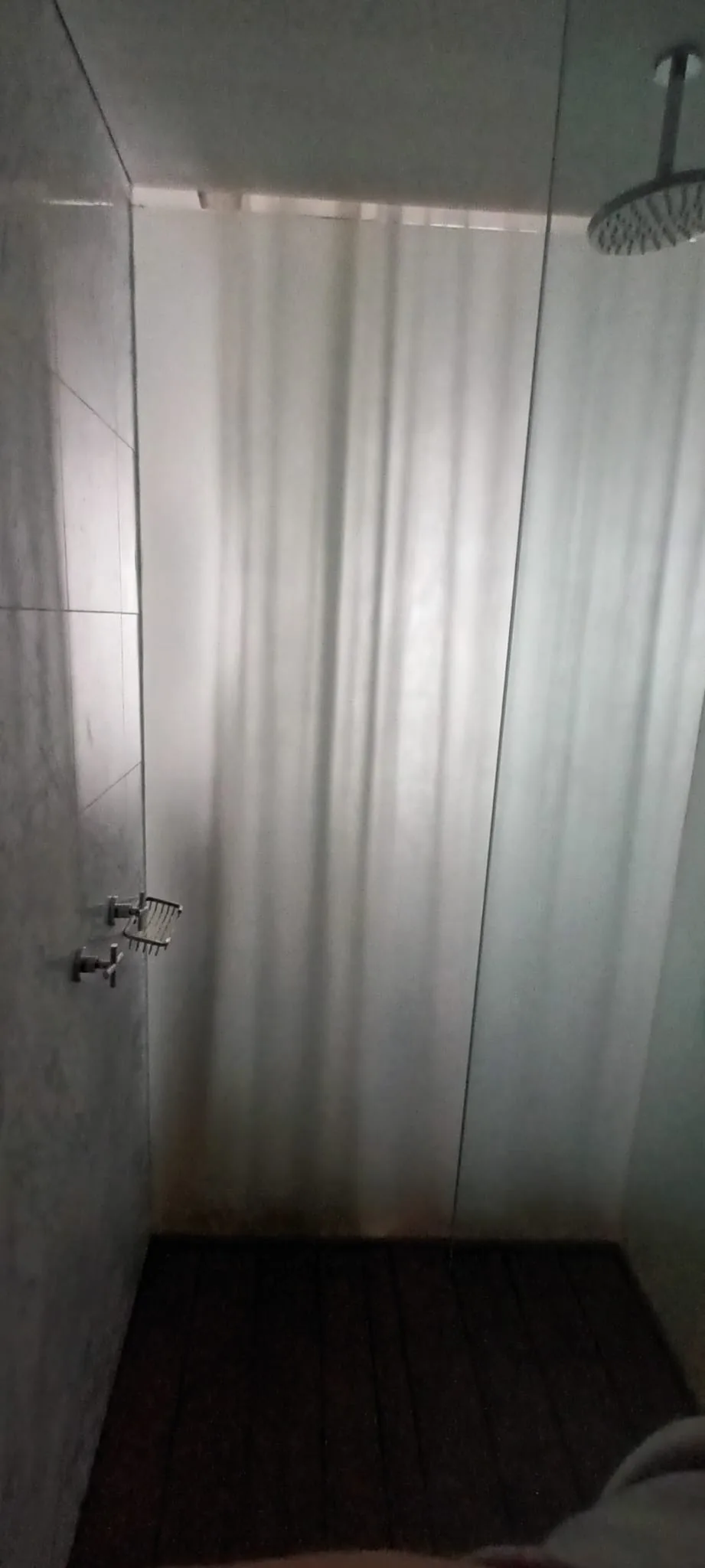 Duschvorhang im Badezimmer mit grauem Fliesenboden
