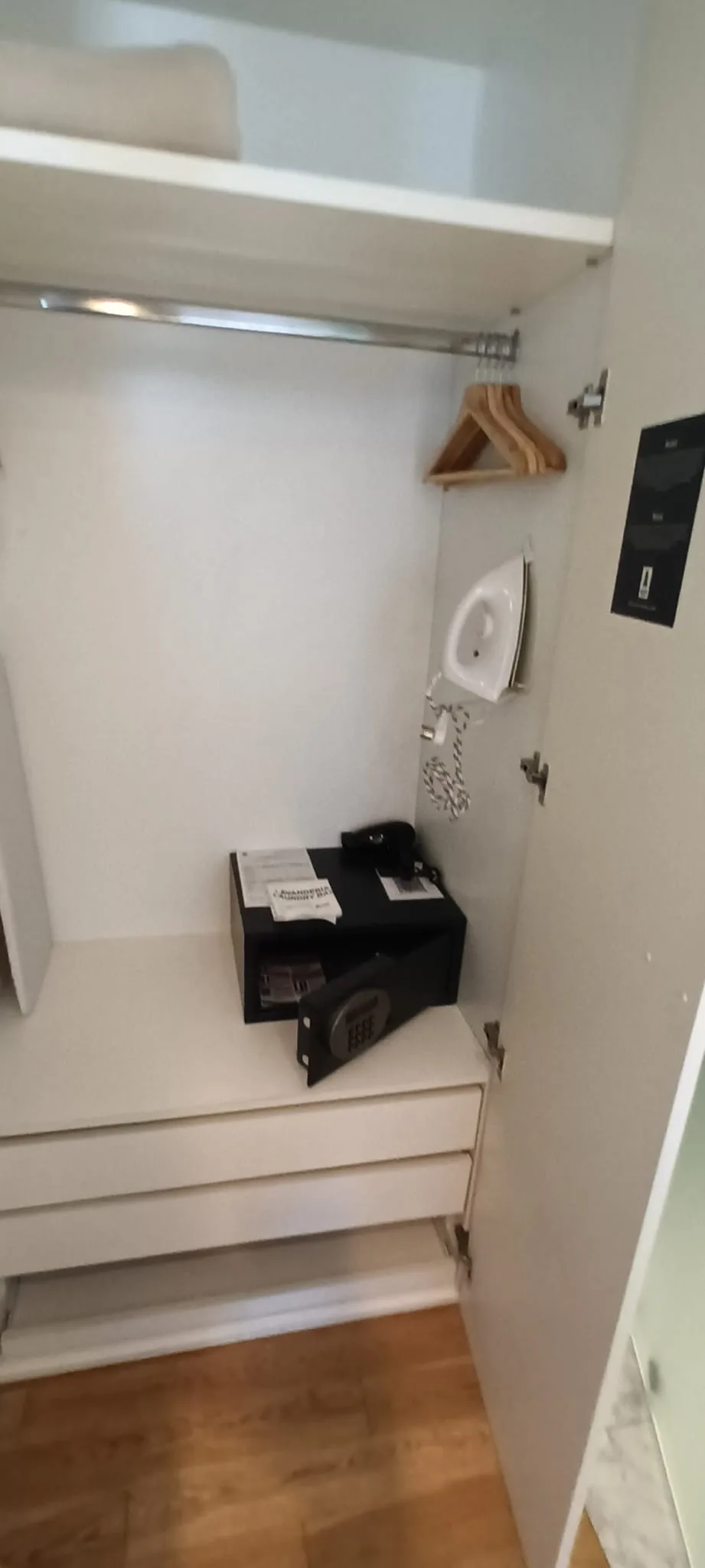 Schrank mit Bügeleisen und Kleiderbügeln in einem Hotelzimmer
