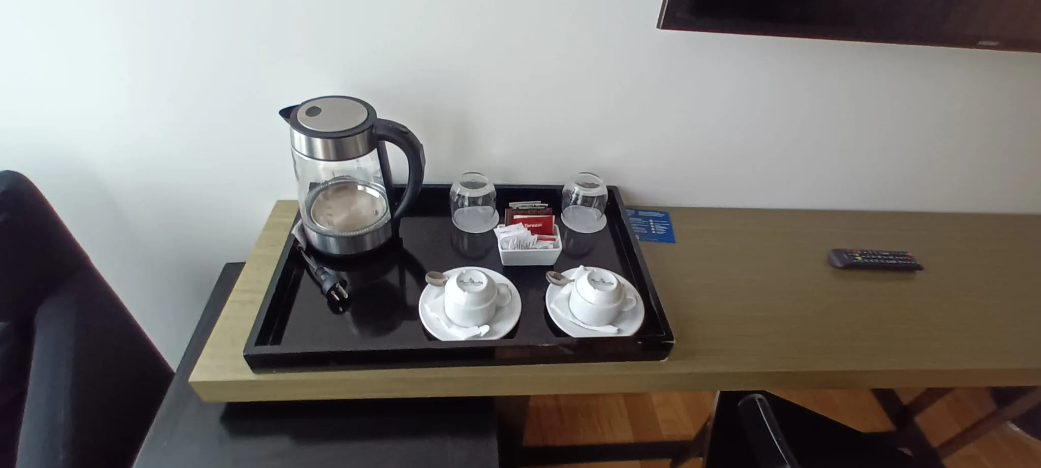 Hotelzimmertisch mit Tee-Set und Fernbedienung