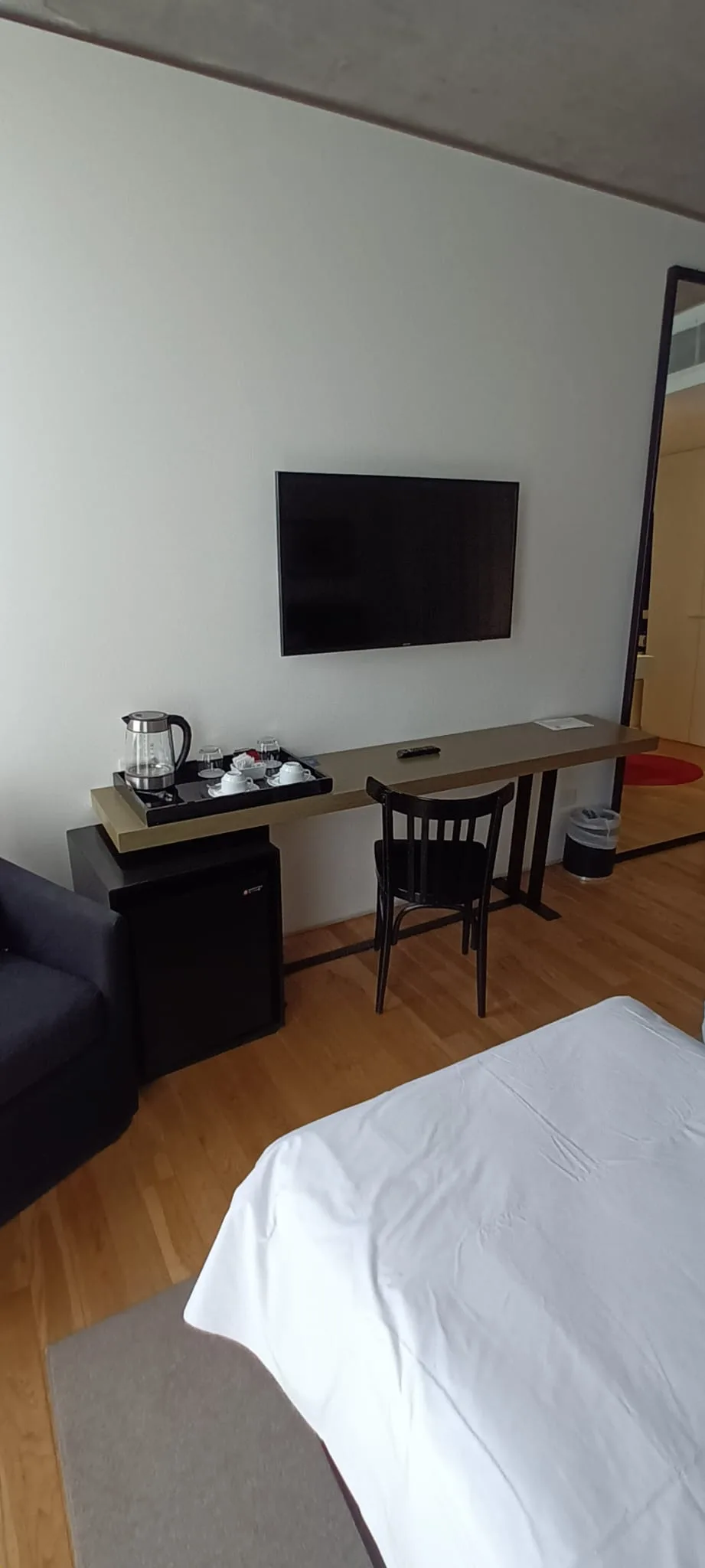Hotelzimmer mit Doppelbett, Tisch und Fernseher