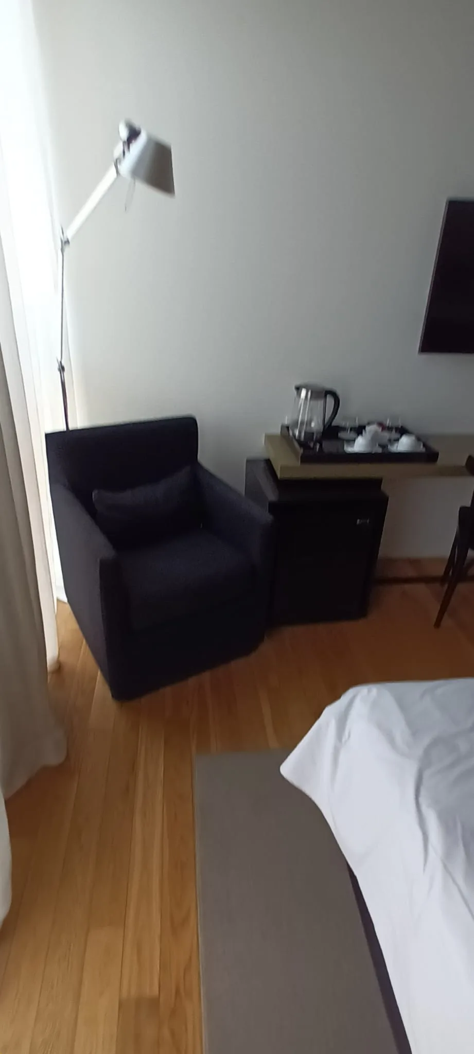 Hotelzimmer mit Sessel und Stehlampe