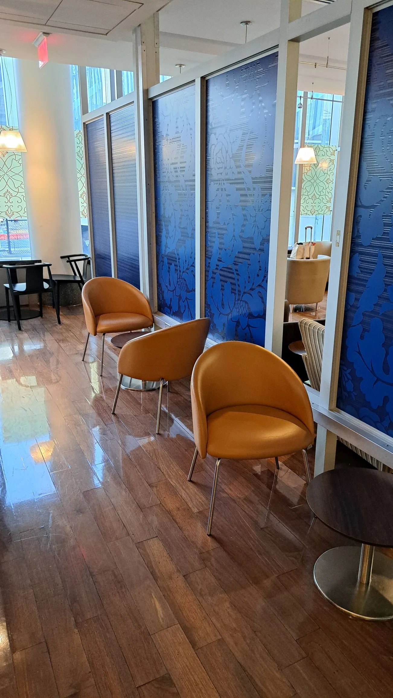 Lounge mit Sesseln und getönten Glaswänden