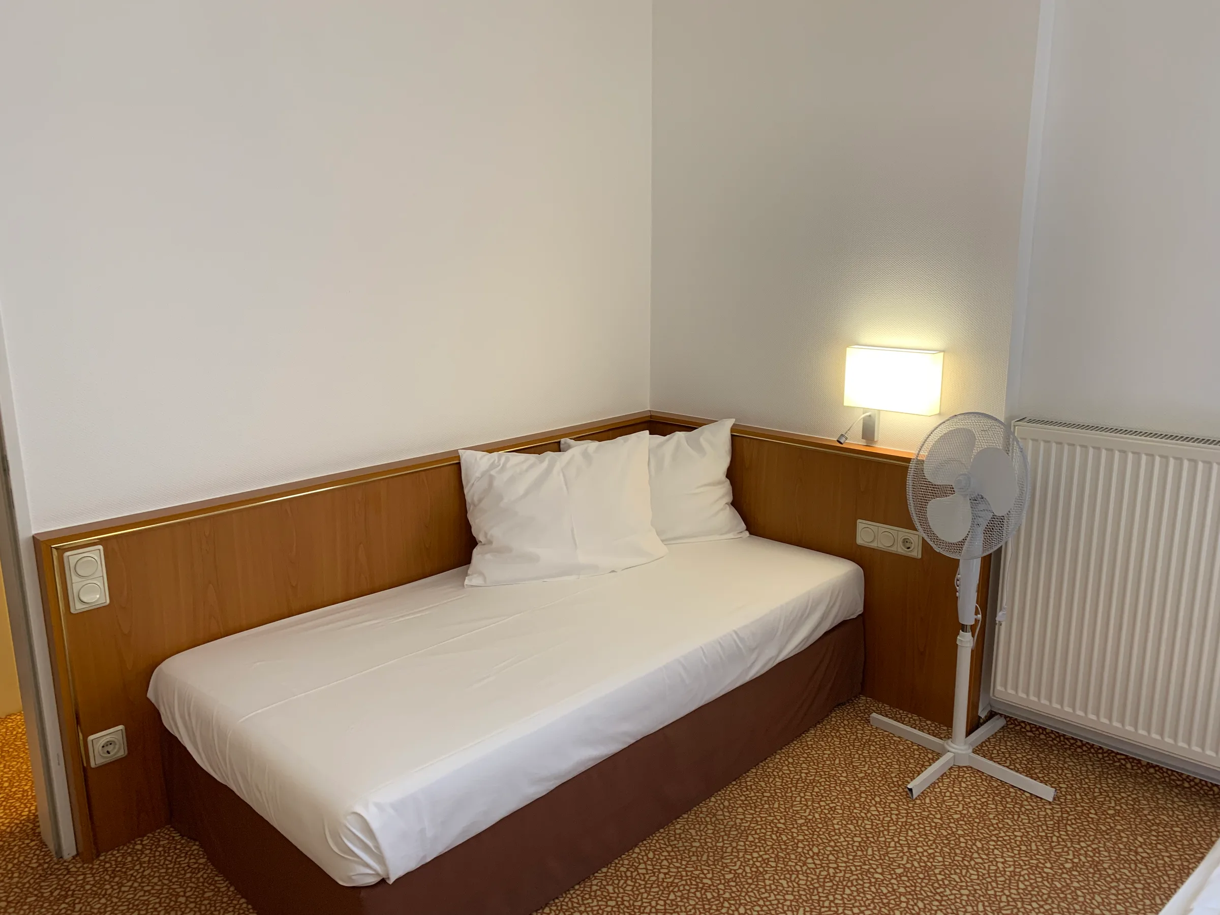 Hotelzimmer mit Doppelbett und Nachttischlampe