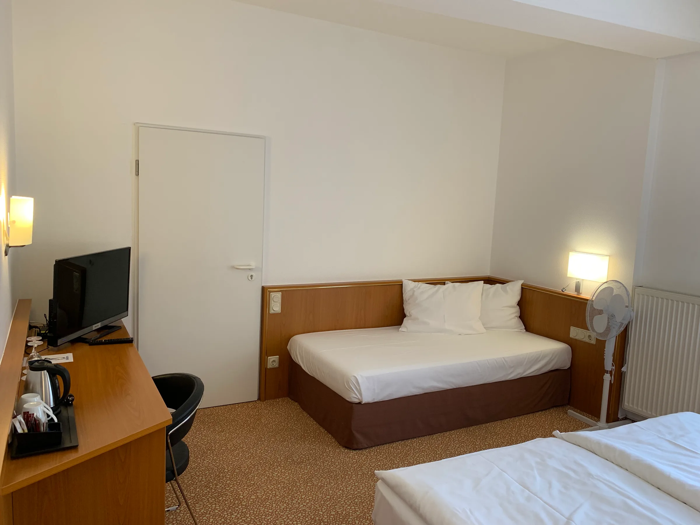 Hotelzimmer mit Doppelbett und Schreibtisch
