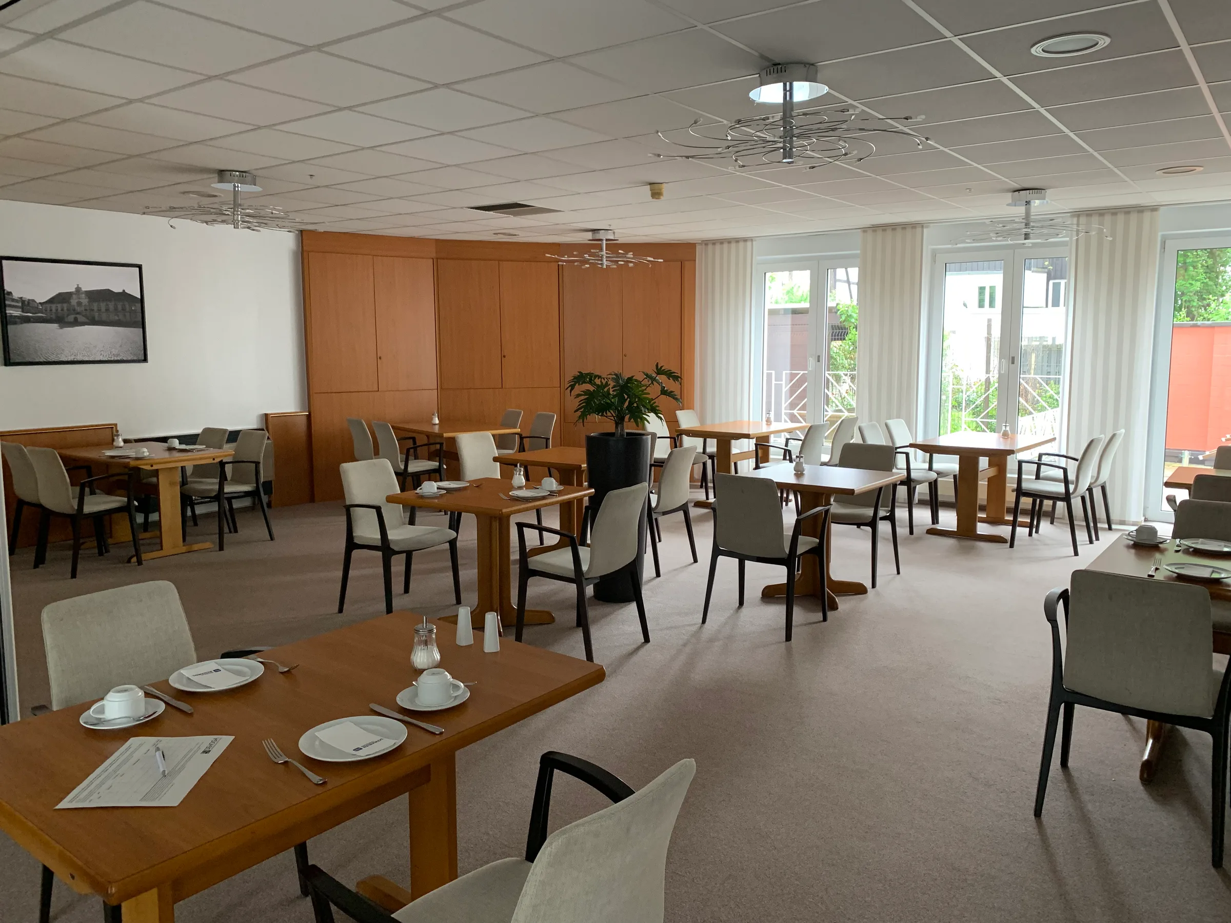 Esszimmer mit Holztischen und Stühlen in neutralen Farben