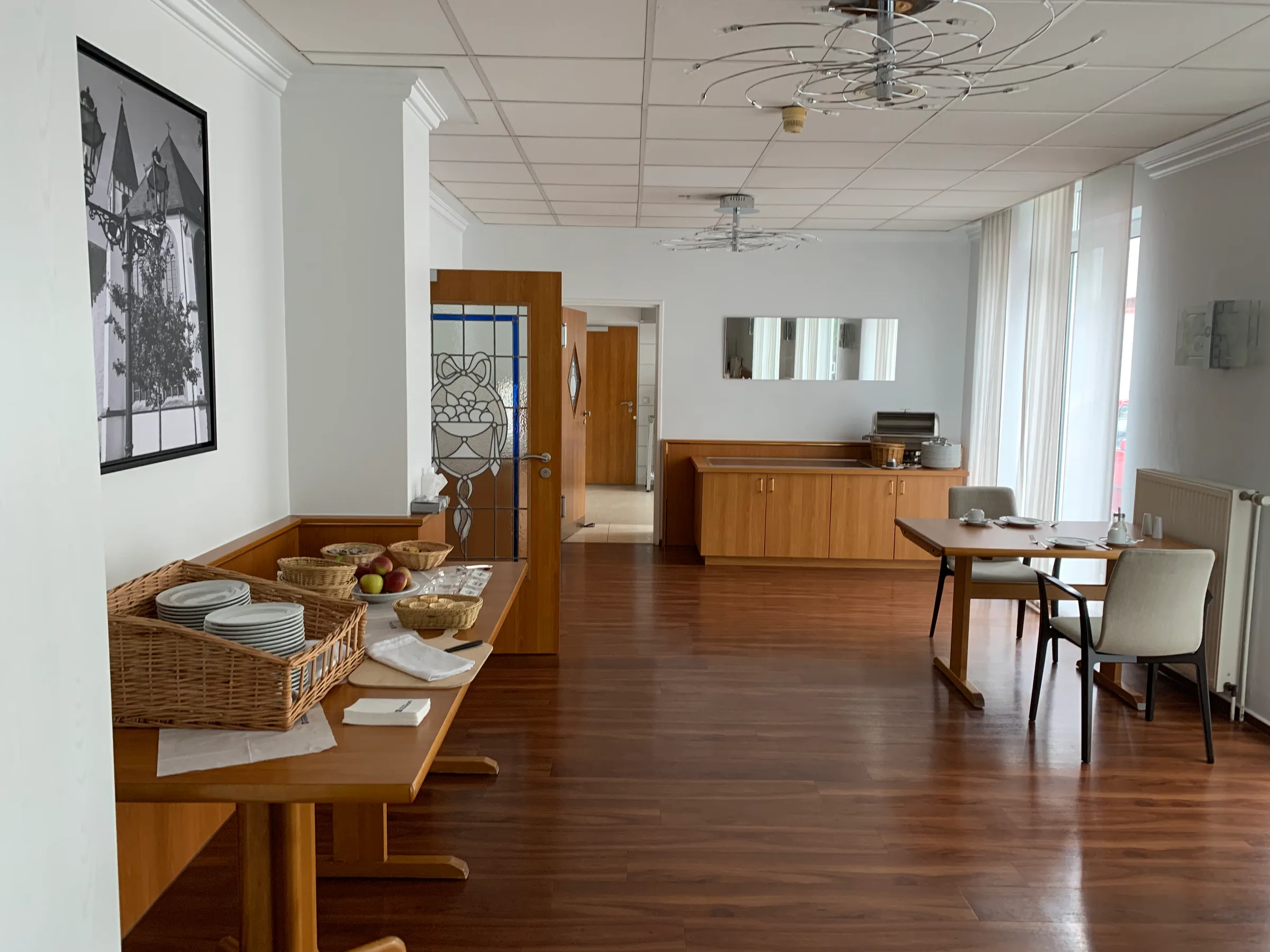 Hotellobby mit Tischen und Küchenbereich