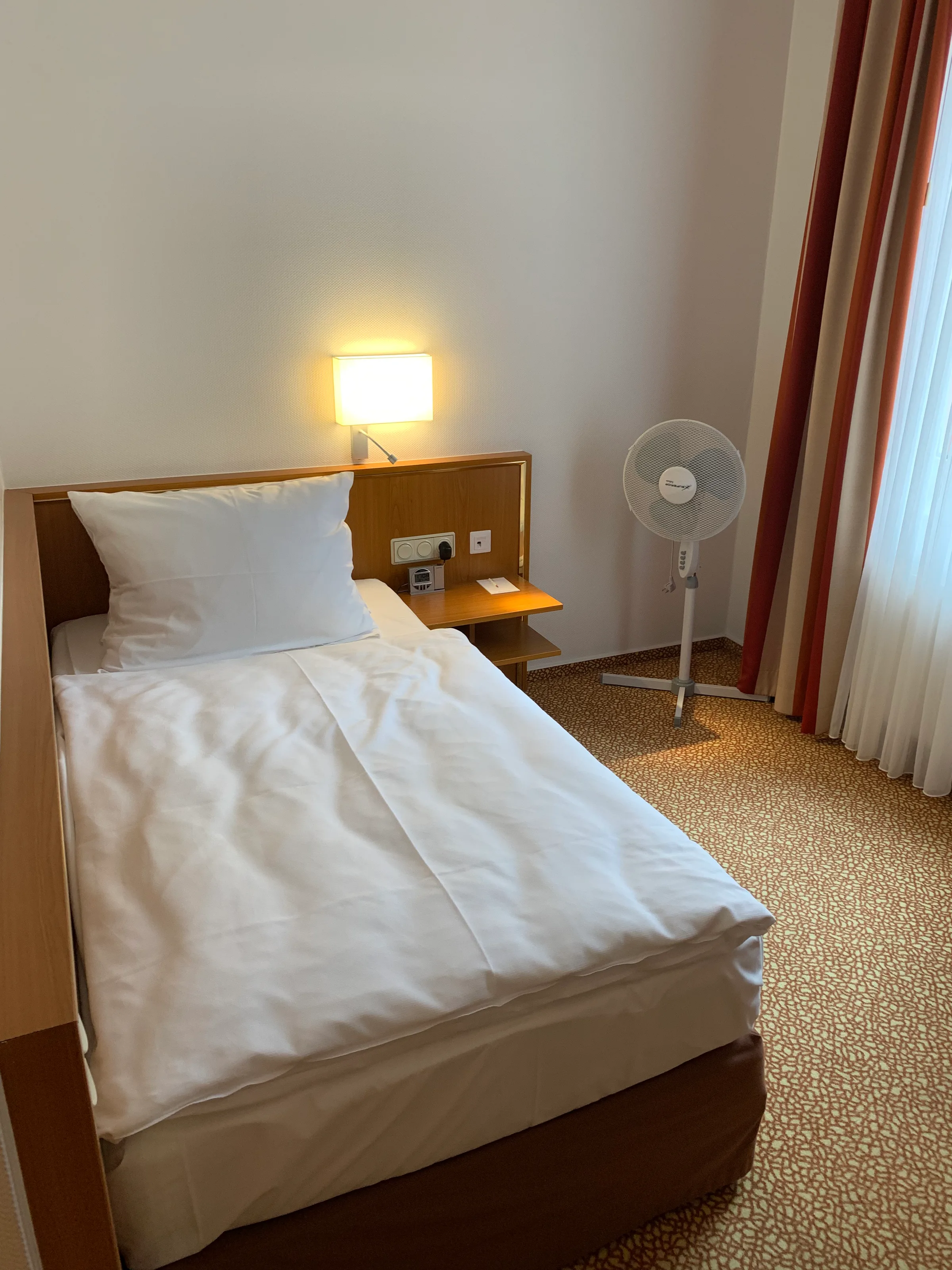 Hotelzimmer mit Doppelbett und Nachttischlampe