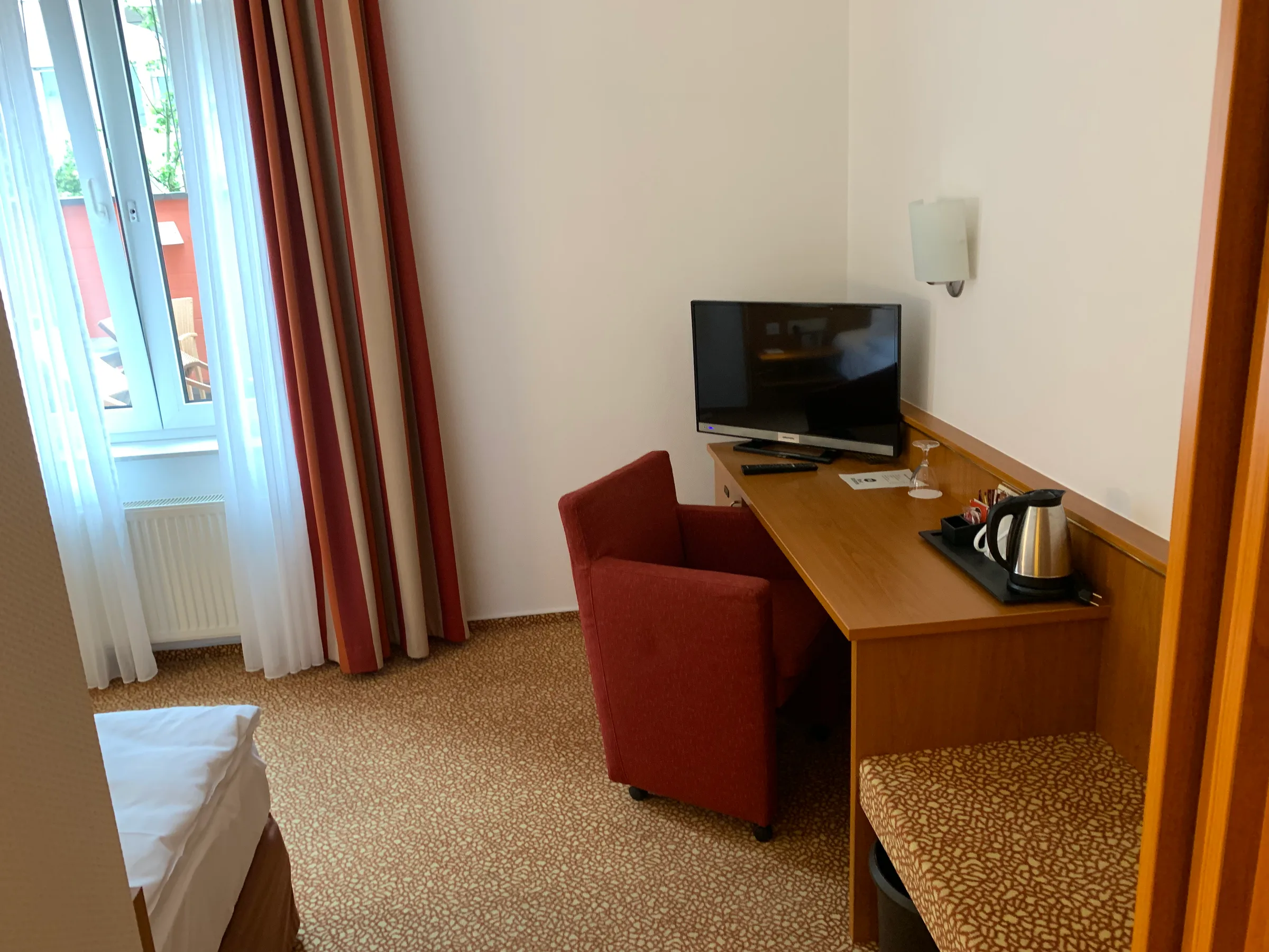 Hotelzimmer mit Schreibtisch und Fernseher