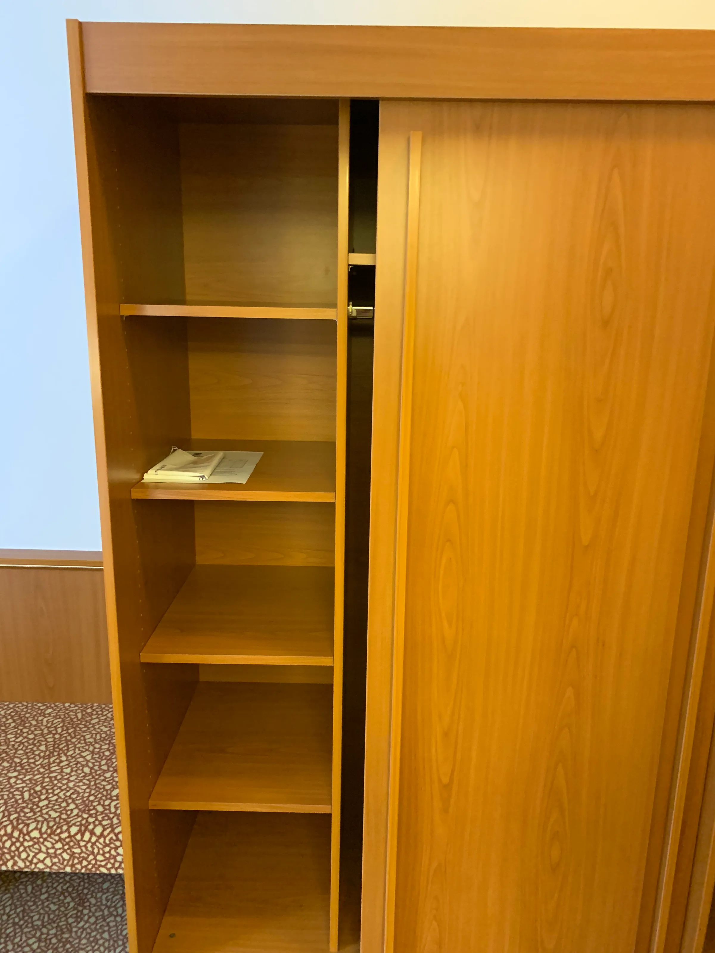 Holzschrank mit offener Tür und einigen Regalen