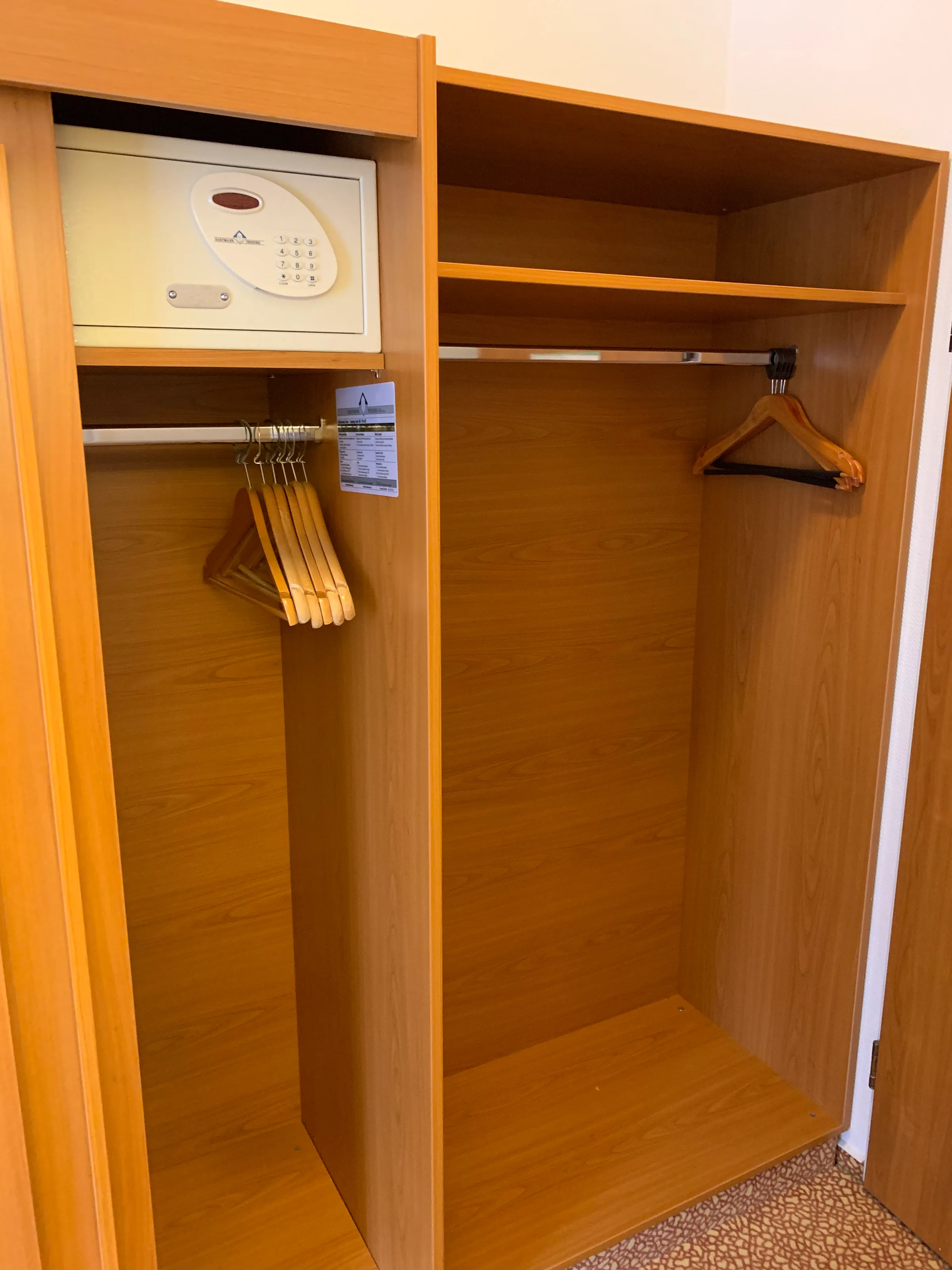 Hotelgarderobe mit Kleiderbügeln und Safe