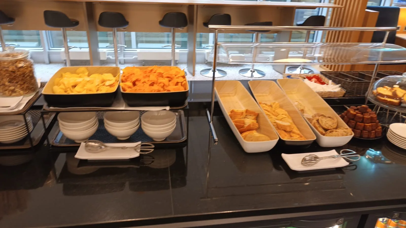 Buffet mit Chips, Brot und Gebäck auf einem Flughafen-Lounge-Tisch