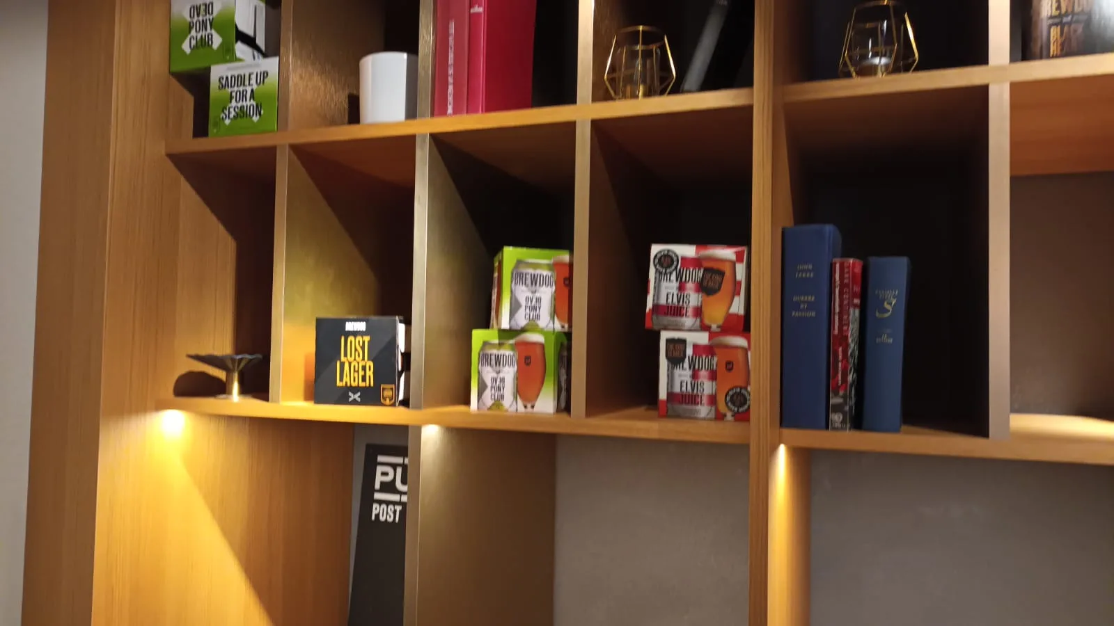 Holzregal mit Büchern und Getränkeflaschen