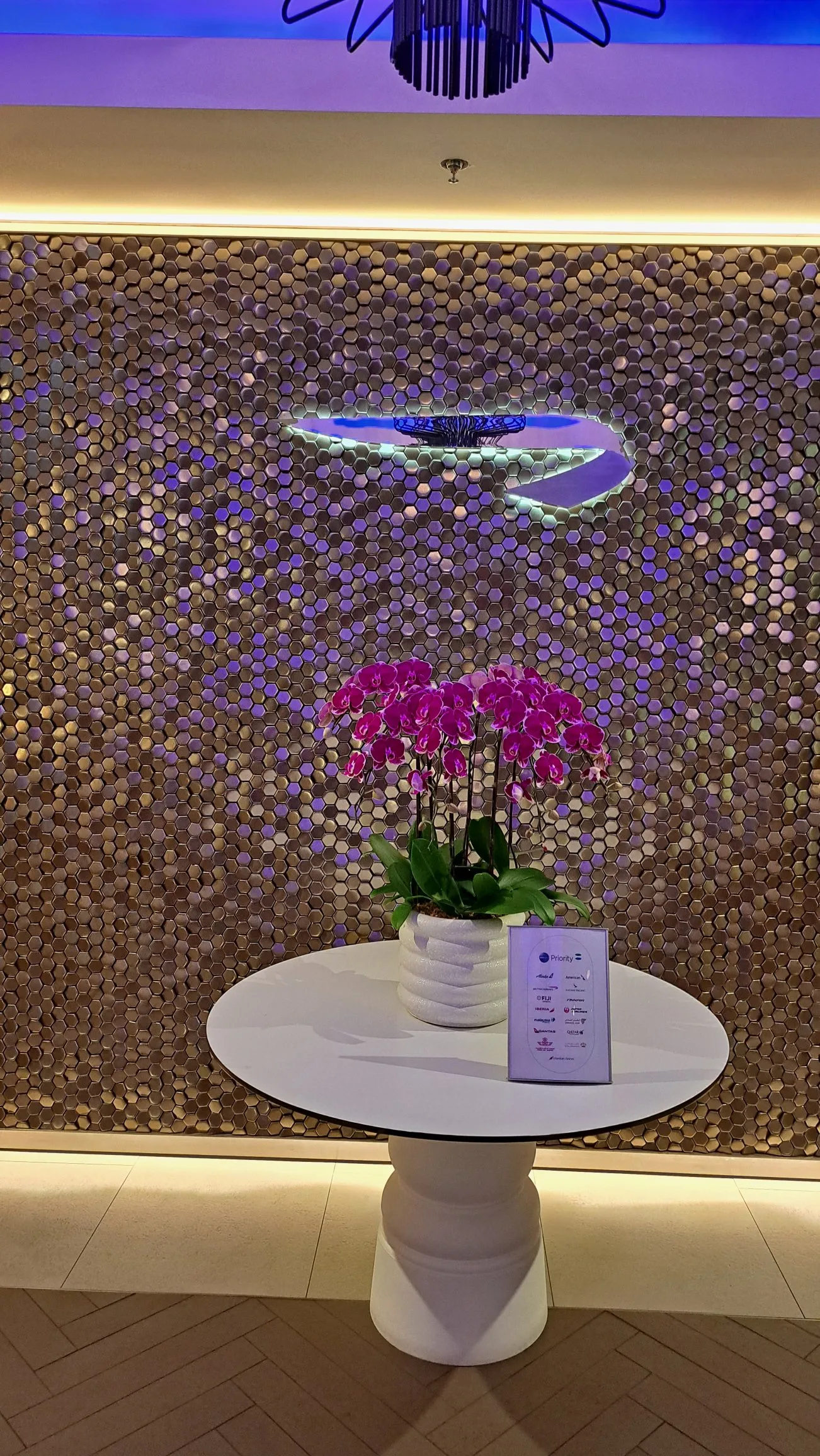 Blumenstrauß auf weißem Tisch vor Wand mit hexagonalen Mustern