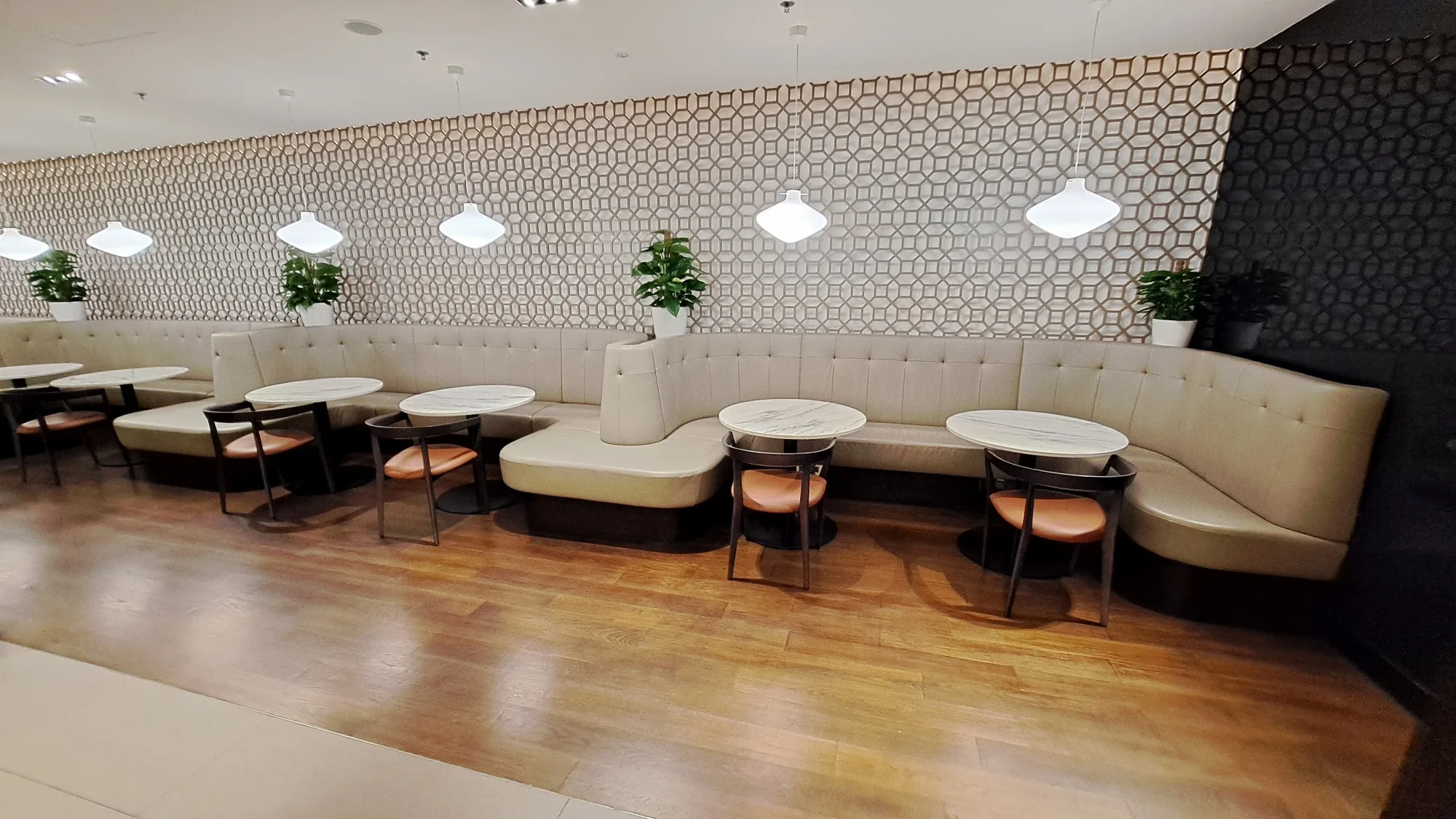 Lounge mit Sitzbank und runden Tischen