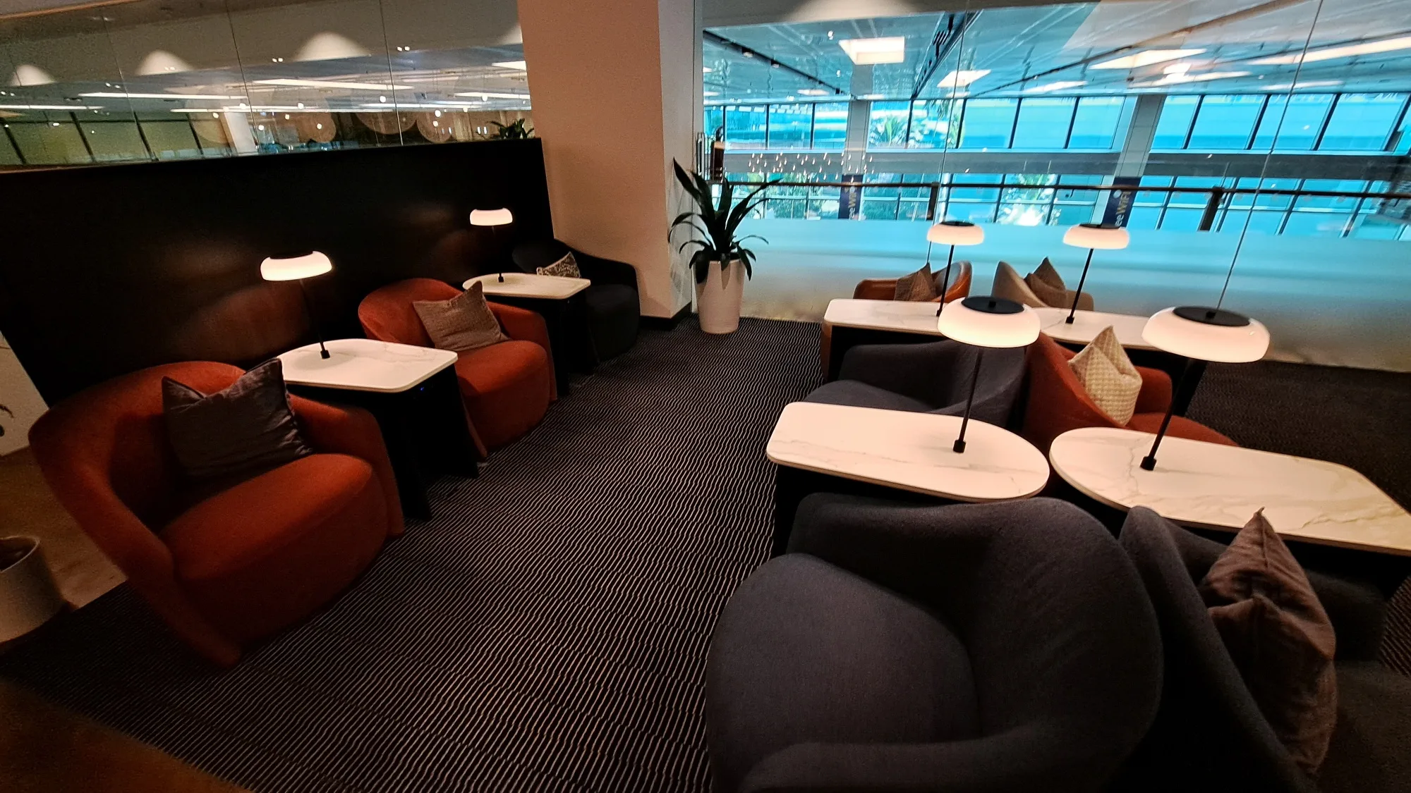 Lounge mit Sesseln und Tischen in warmen Farbtönen