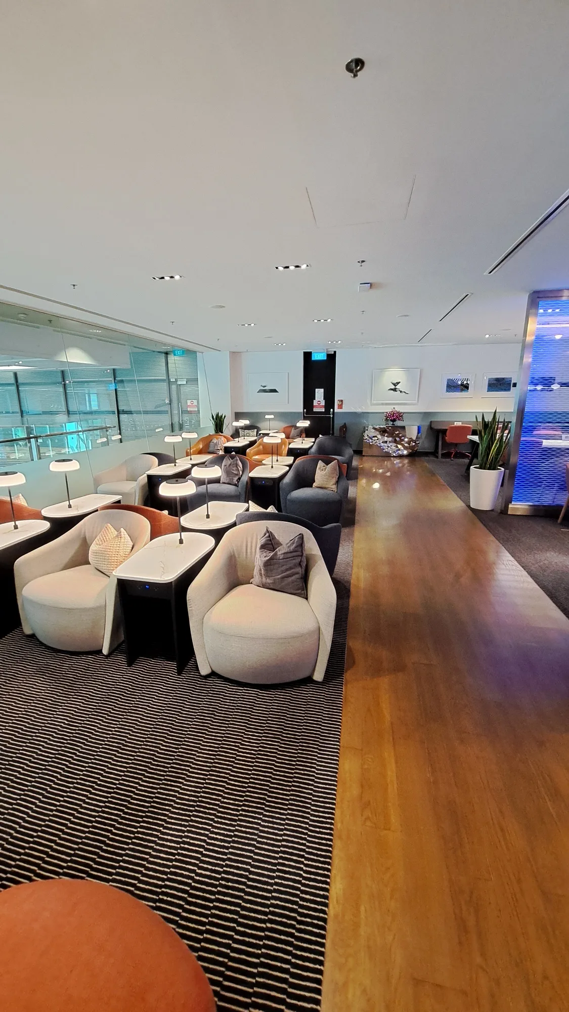 Lounge mit Sesseln und Tischen in neutralen Farben