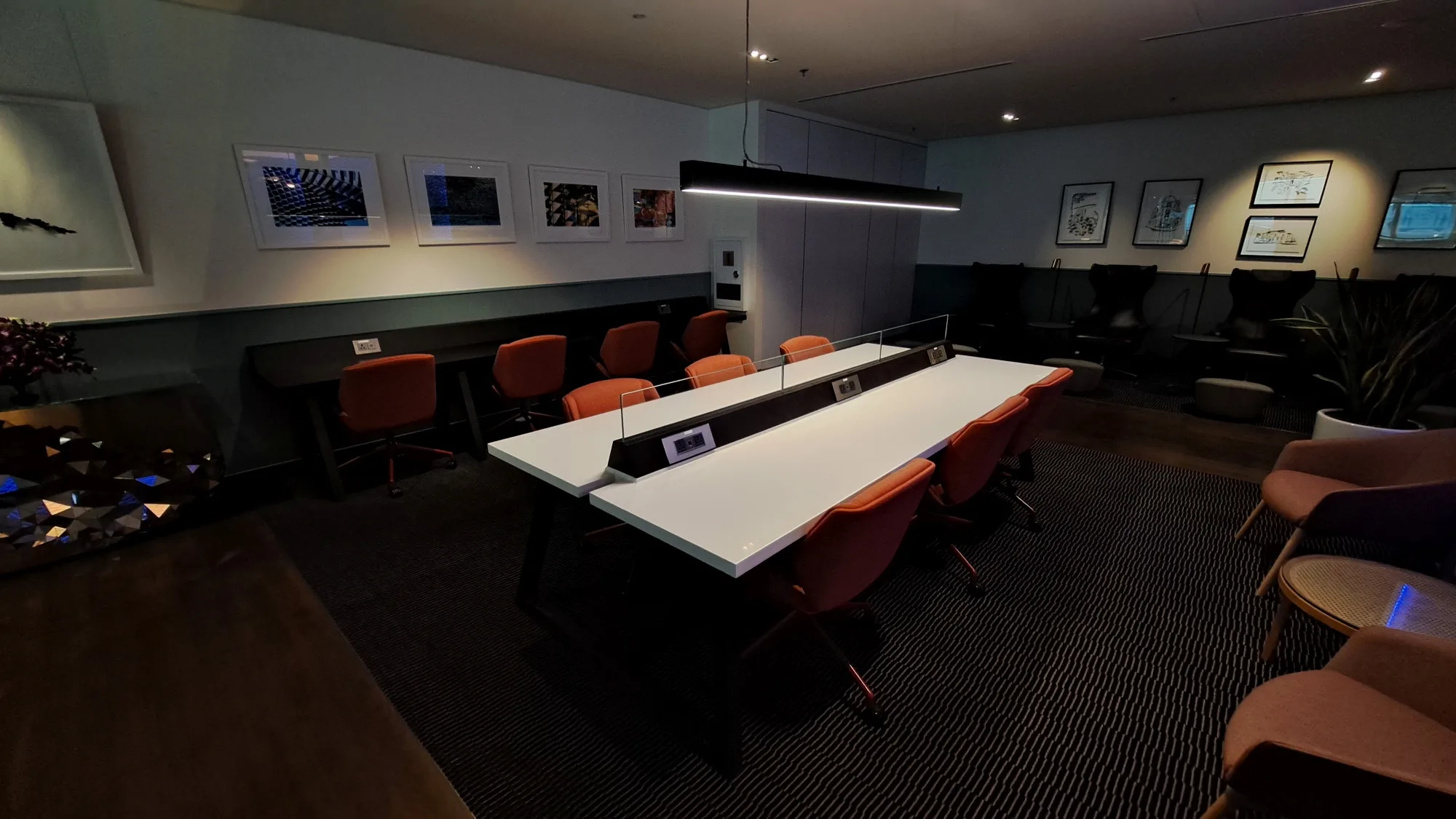 Lounge mit Tischen und Stühlen in Orange und Grau