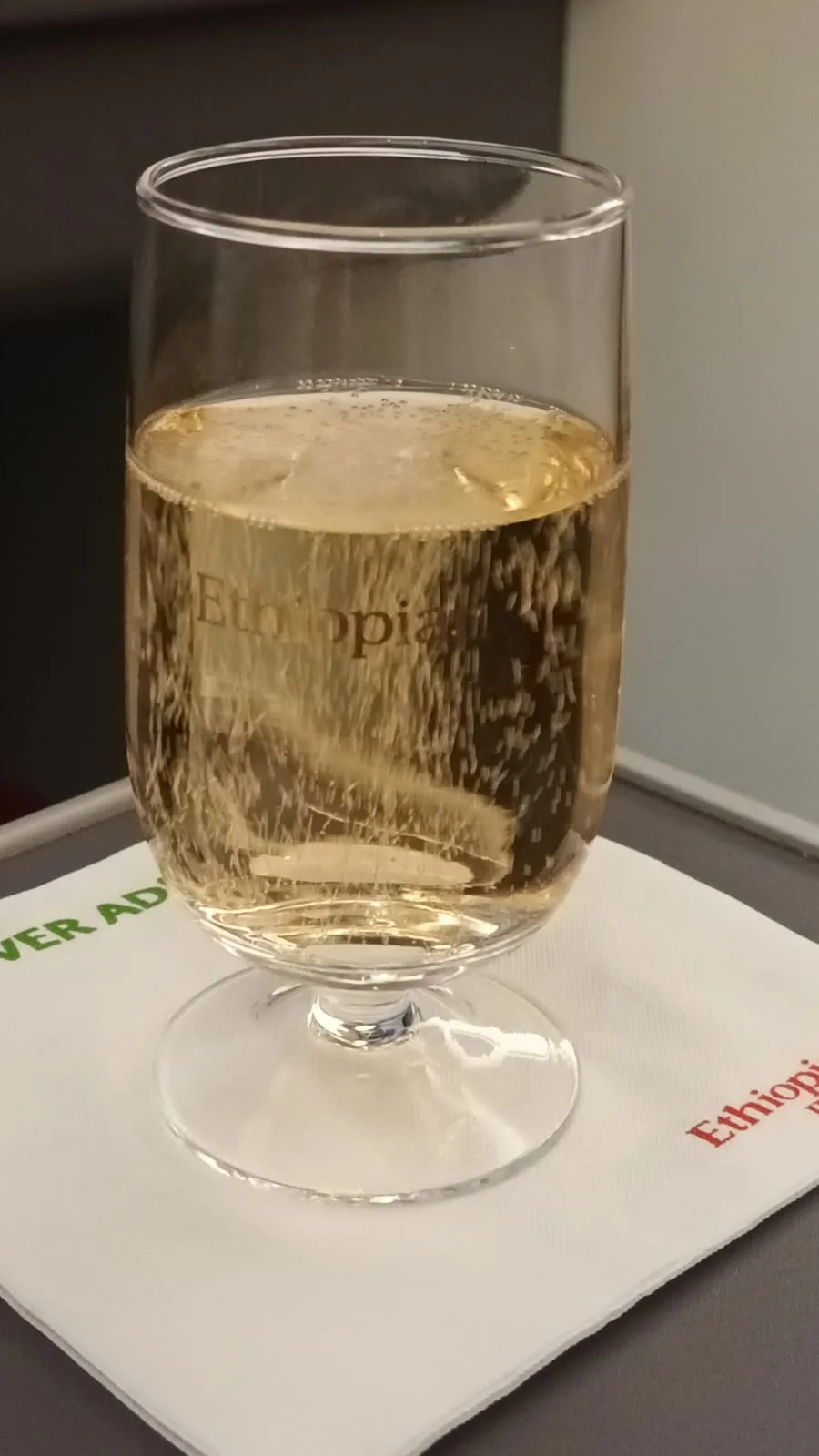 Glas mit Champagner auf Serviette mit Etikett