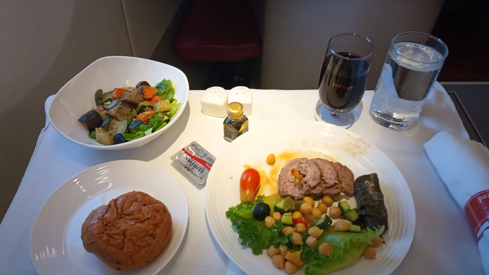 Gesunde Mahlzeit im Business Class mit Salat, Fleischgericht und Brot