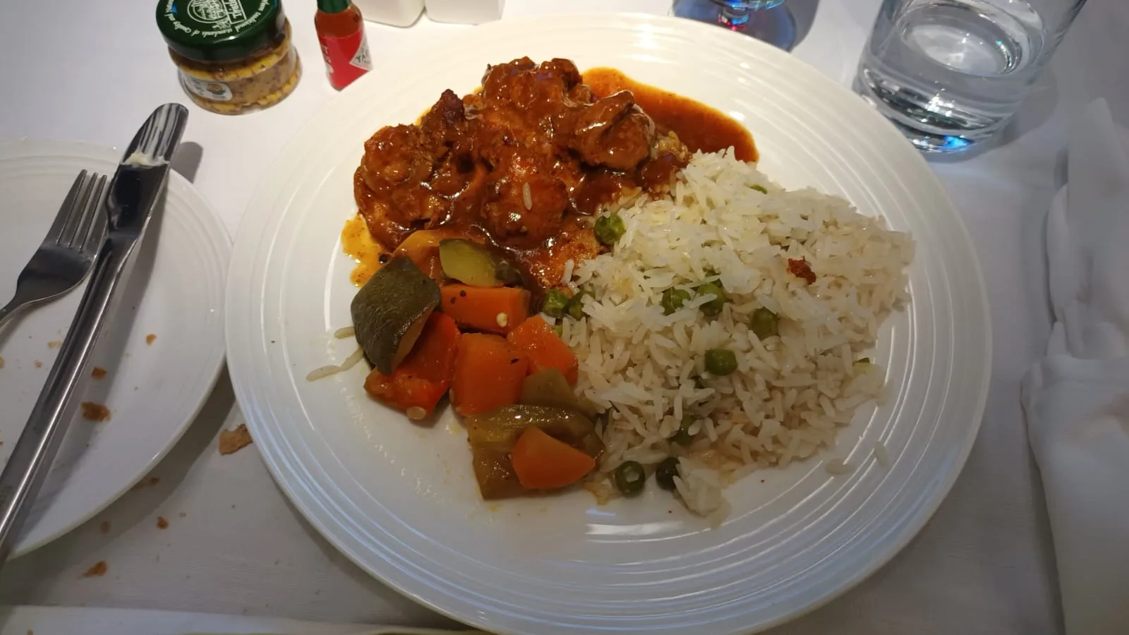 Gedeckter Tisch mit Gericht aus Reis, Gemüse und Fleisch in Soße