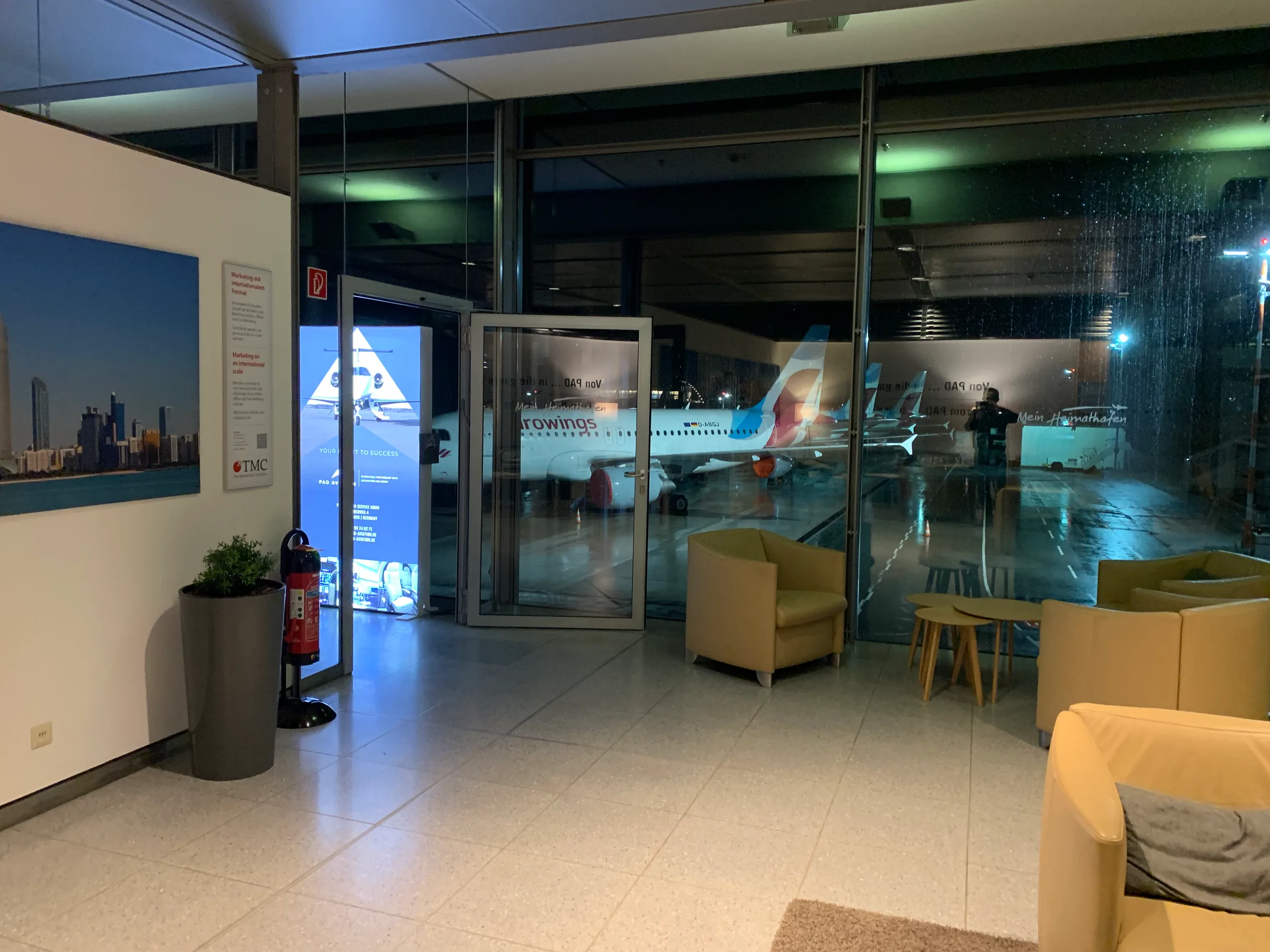 Business Lounge im Flughafen Paderborn-Lippstadt mit Sitzmöbeln und Blick auf das Flugzeug
