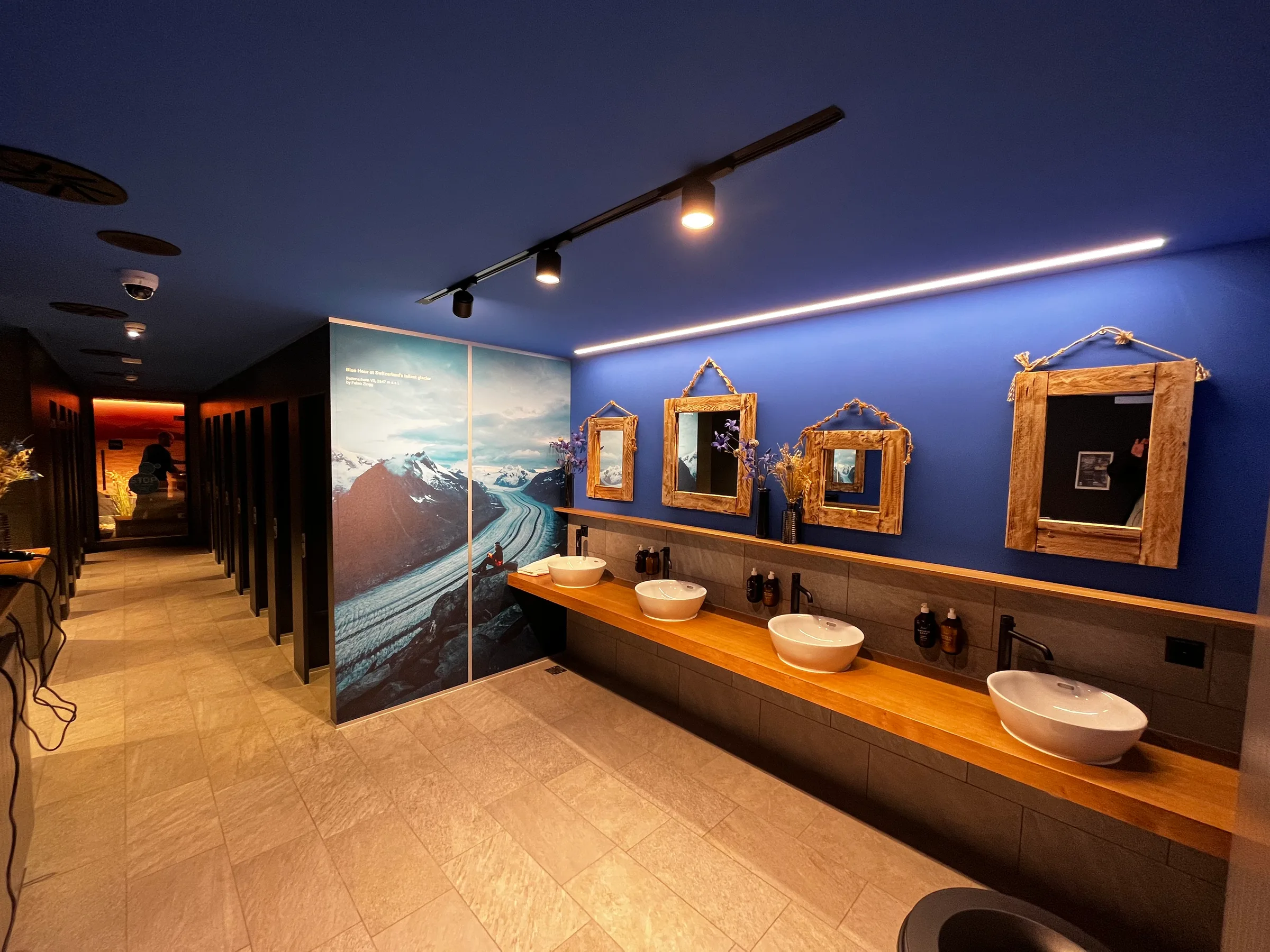 Wartezimmer mit Waschbecken und Spiegeln an blauer Wand