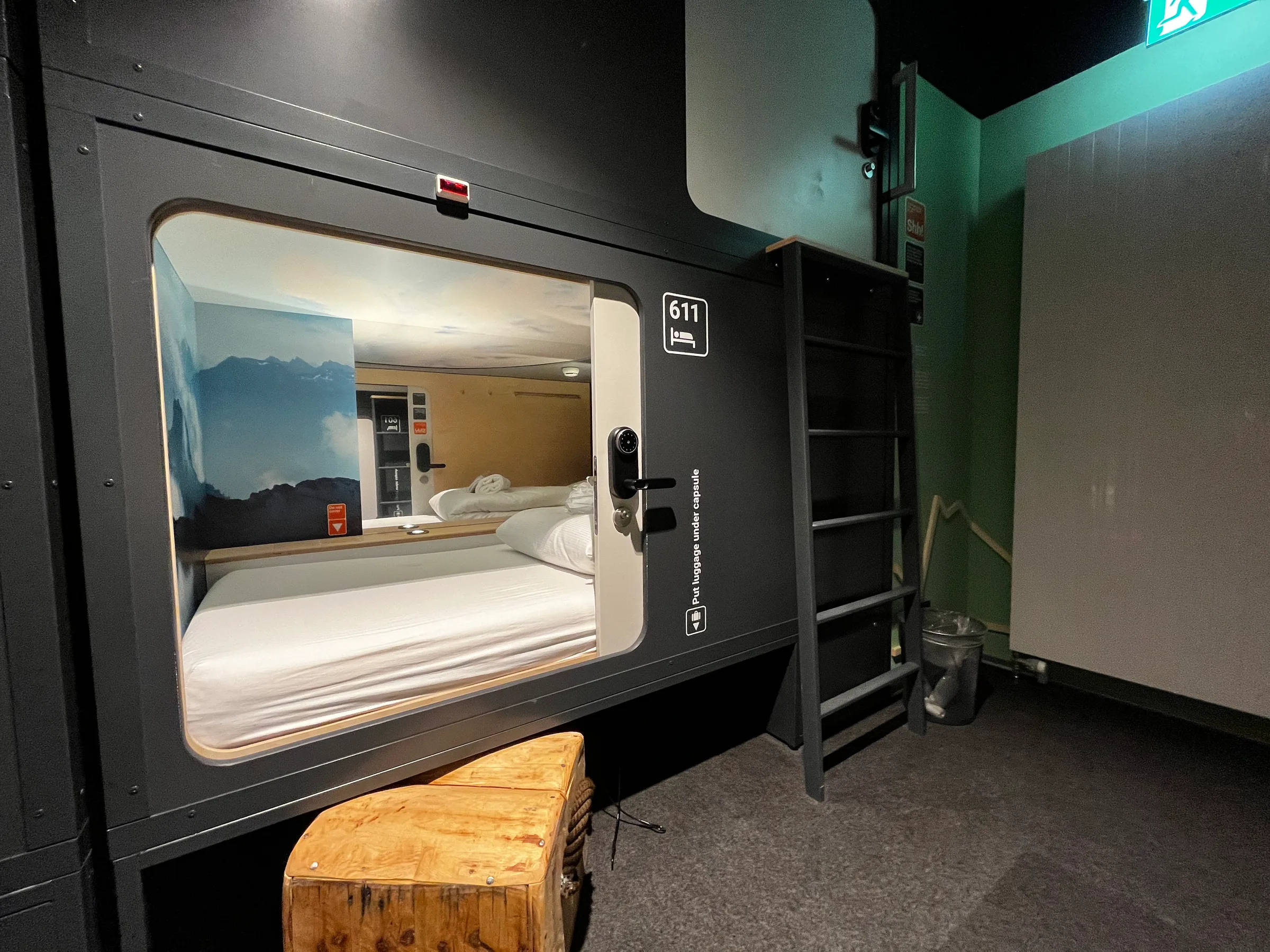 Kapselhotel-Zimmer mit Doppelbett und Fenster