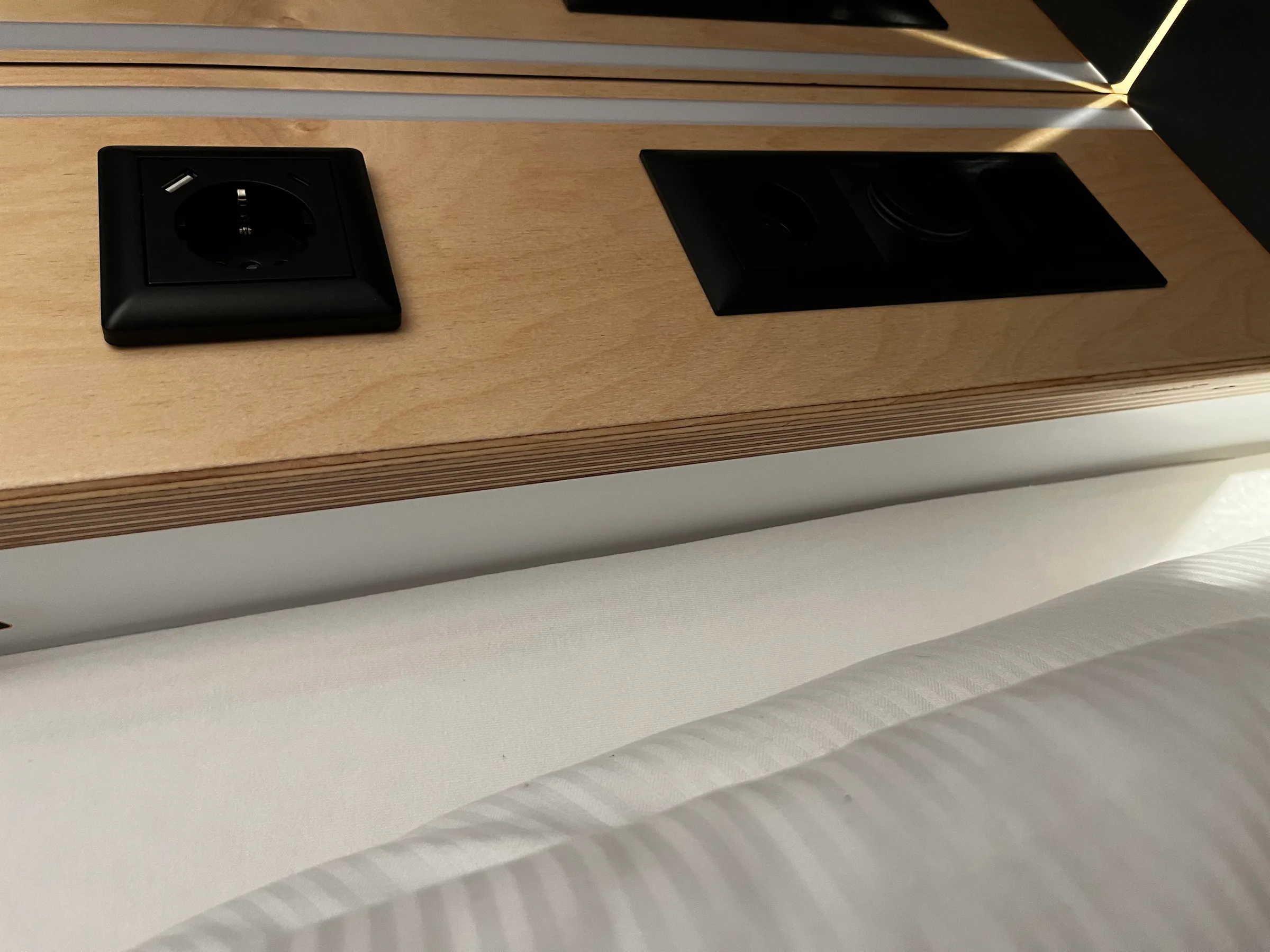 Holzschrank mit Steckdose und Kochfeld in einem Hotelzimmer