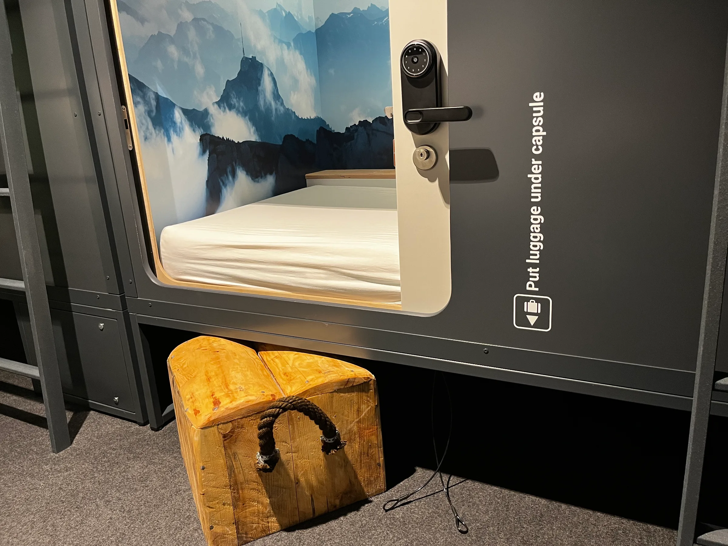 Kapselhotel-Zimmer mit Doppelbett und Bergpanorama