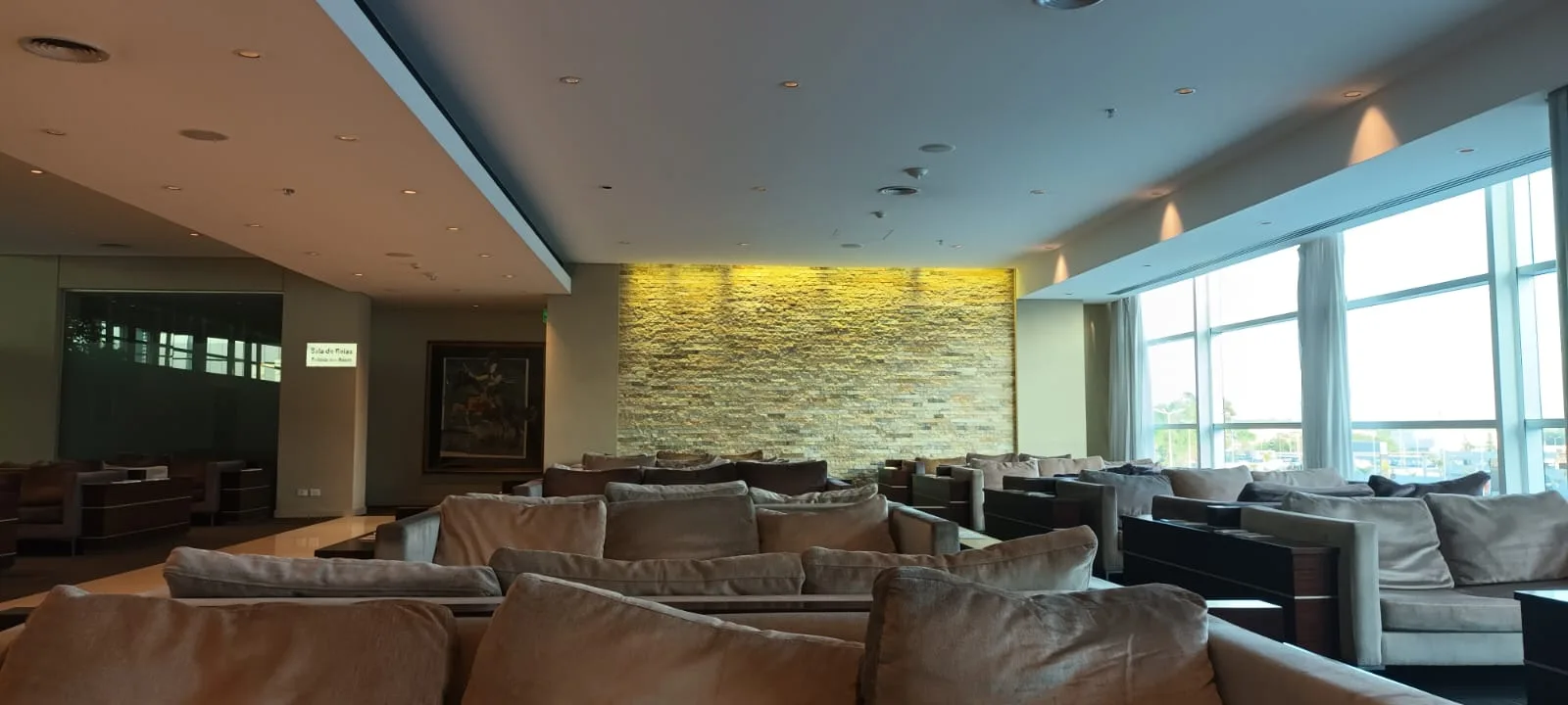 Lounge mit Sesseln und Steinwand im Hintergrund