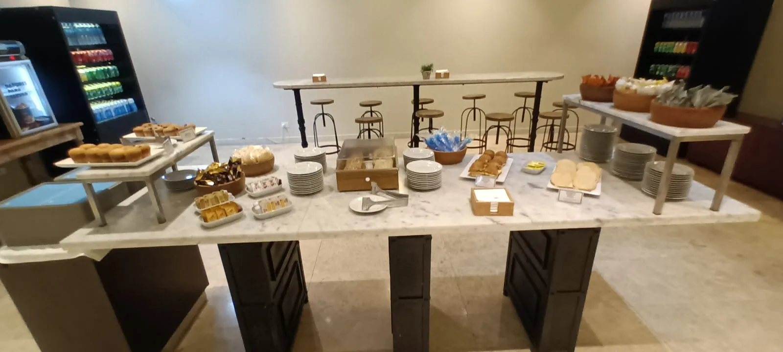 Frühstückstablett mit verschiedenen Gebäck und Kaffee auf Marmorplatte
