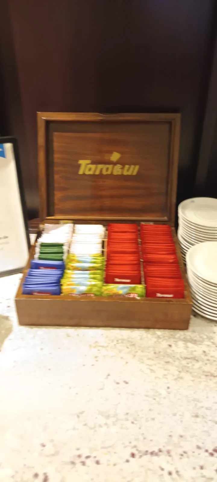 Holzbox mit Teebeuteln und Kaffeebeuteln in verschiedenen Farben