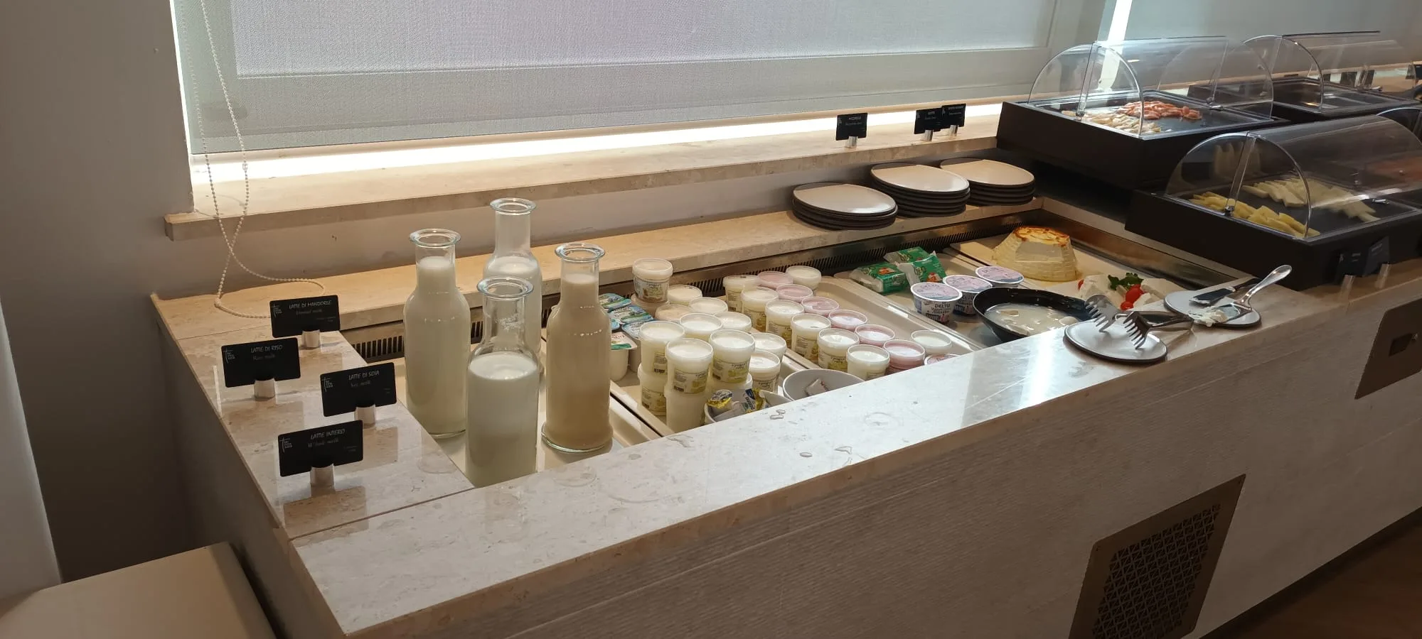 Frühstücksbuffet mit Milchprodukten und Käse auf Holztisch