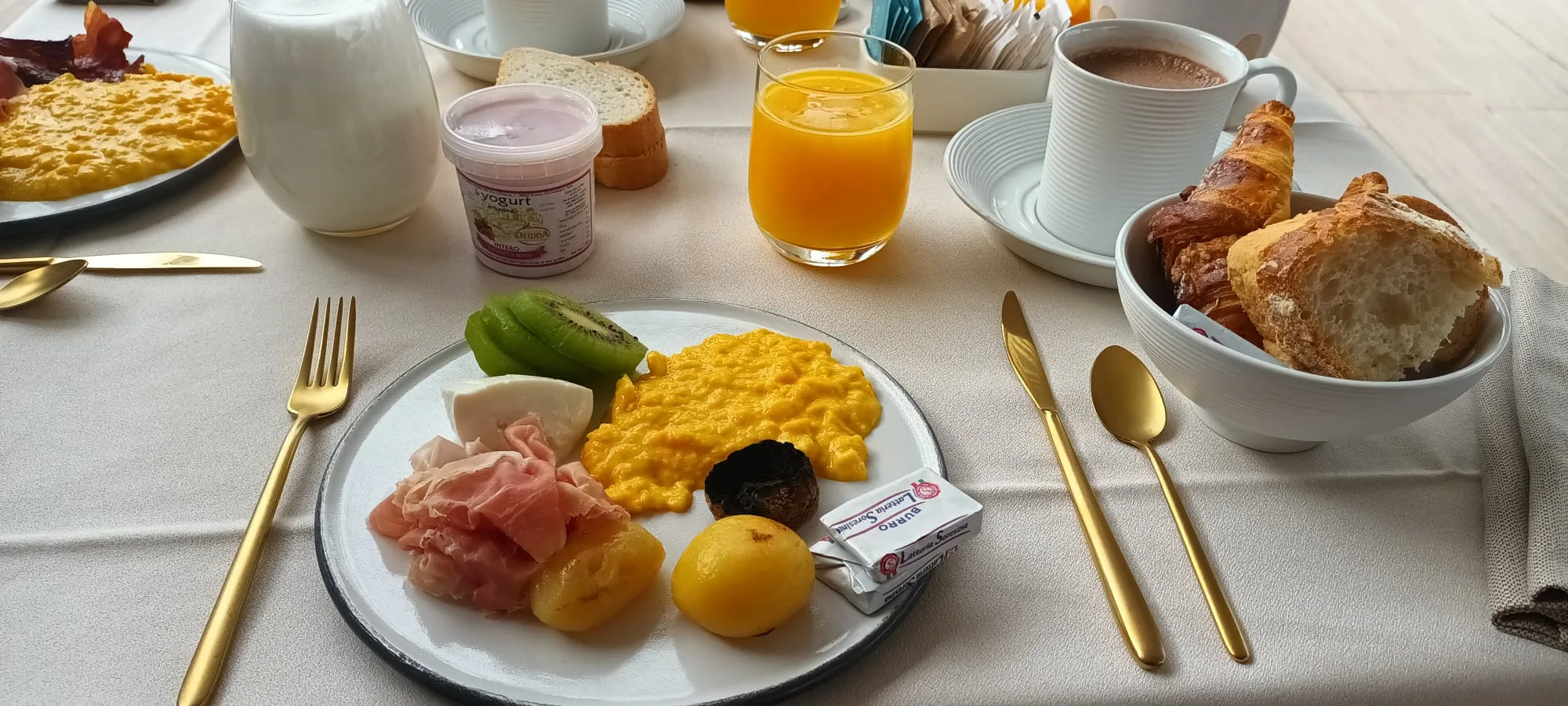 Frühstückstablett mit Eiern, Obst, Brot und Getränken