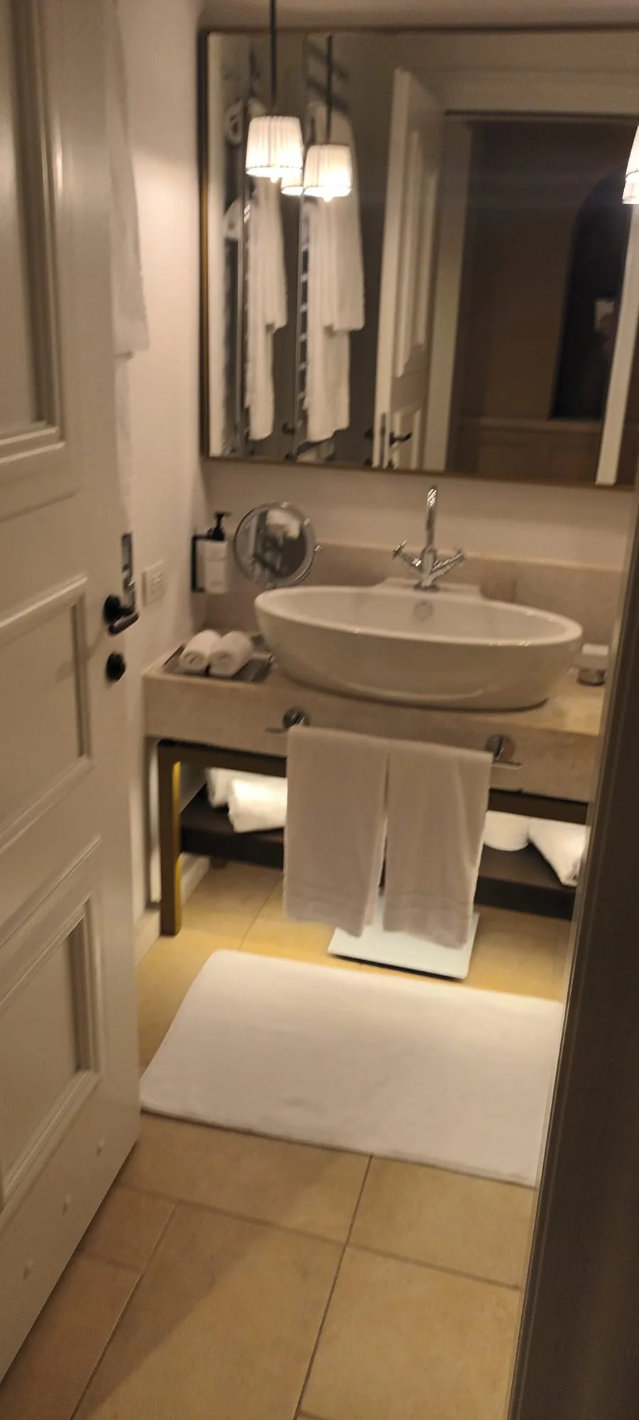 Hotelbadezimmer mit Waschbecken, Spiegel und Handtüchern