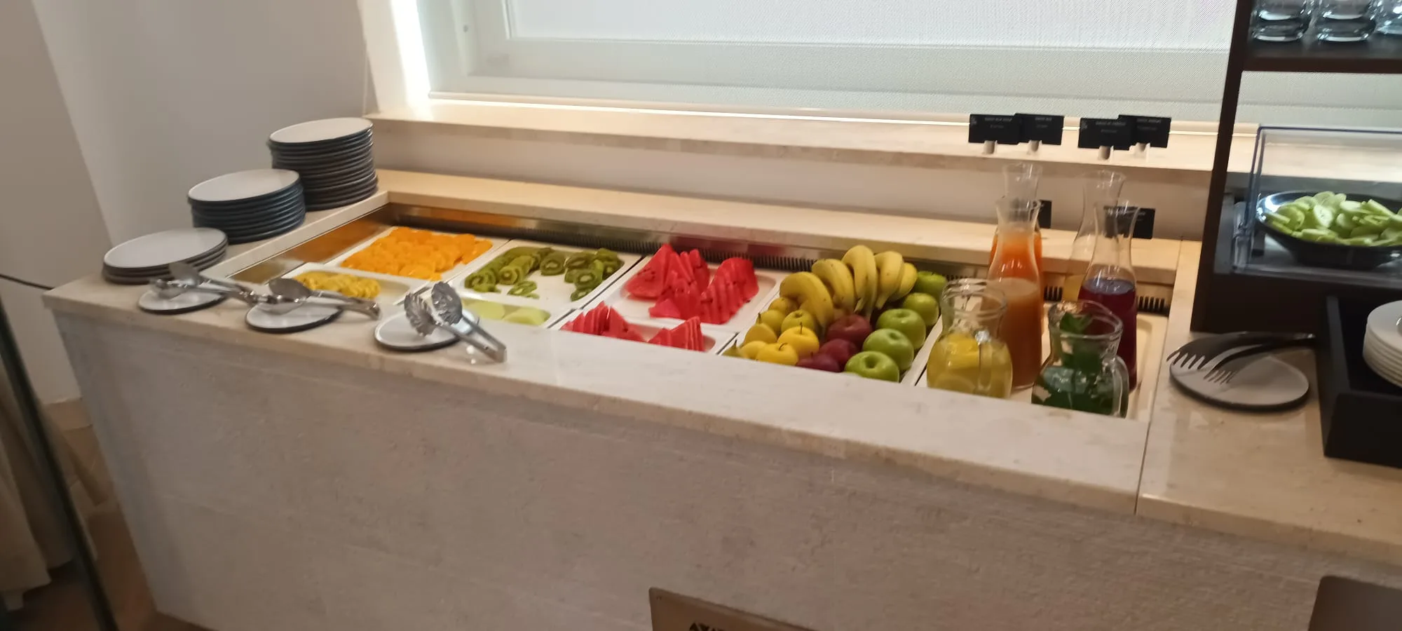 Fruchtsalatbuffet mit verschiedenen Früchten und Saftflaschen