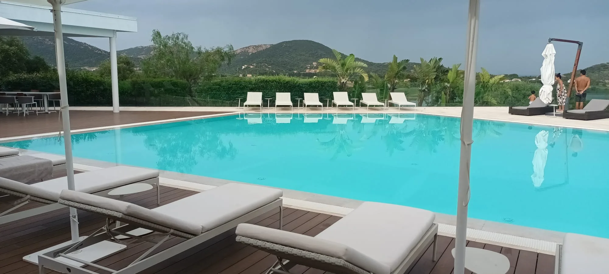 Außenansicht eines Hotels mit Pool und Liegestühlen
