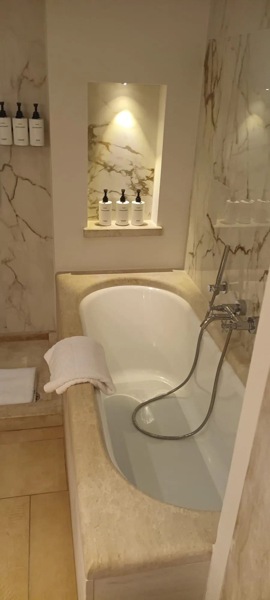 Badezimmer mit Badewanne und Marmorwänden