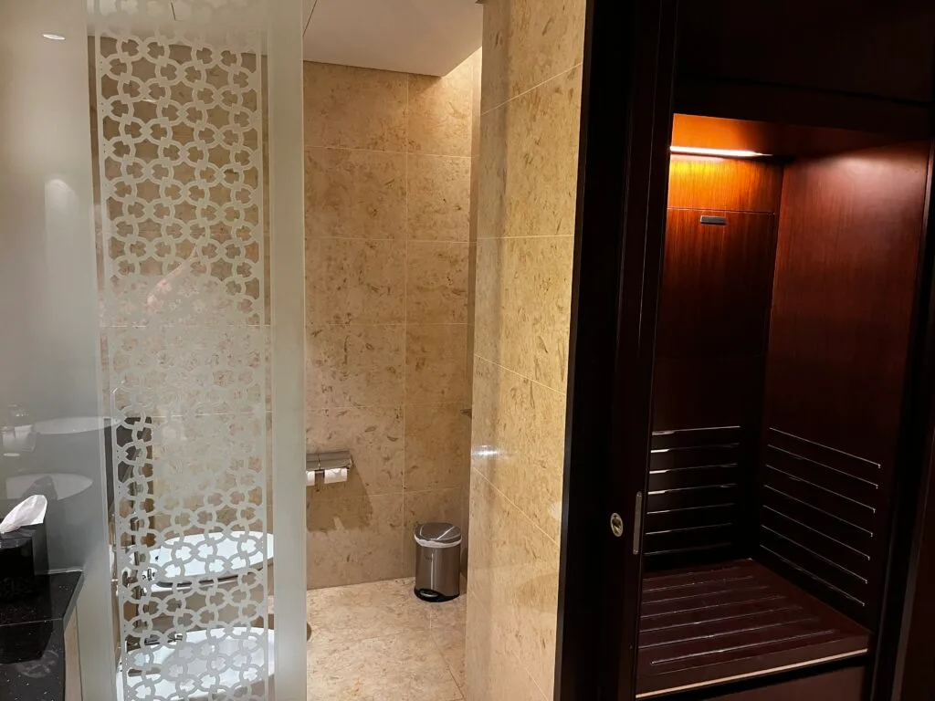 Duschbereich mit Mosaikwand und Holzverkleidung