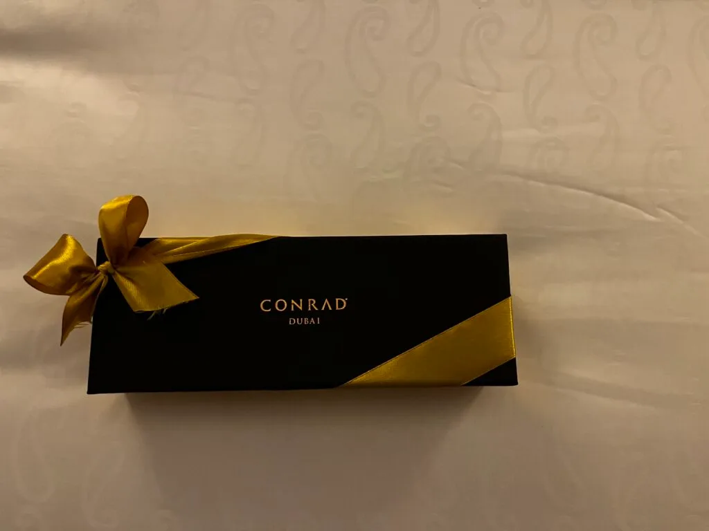 Schwarze Box mit goldener Schleife und Conrad-Dubai-Logo
