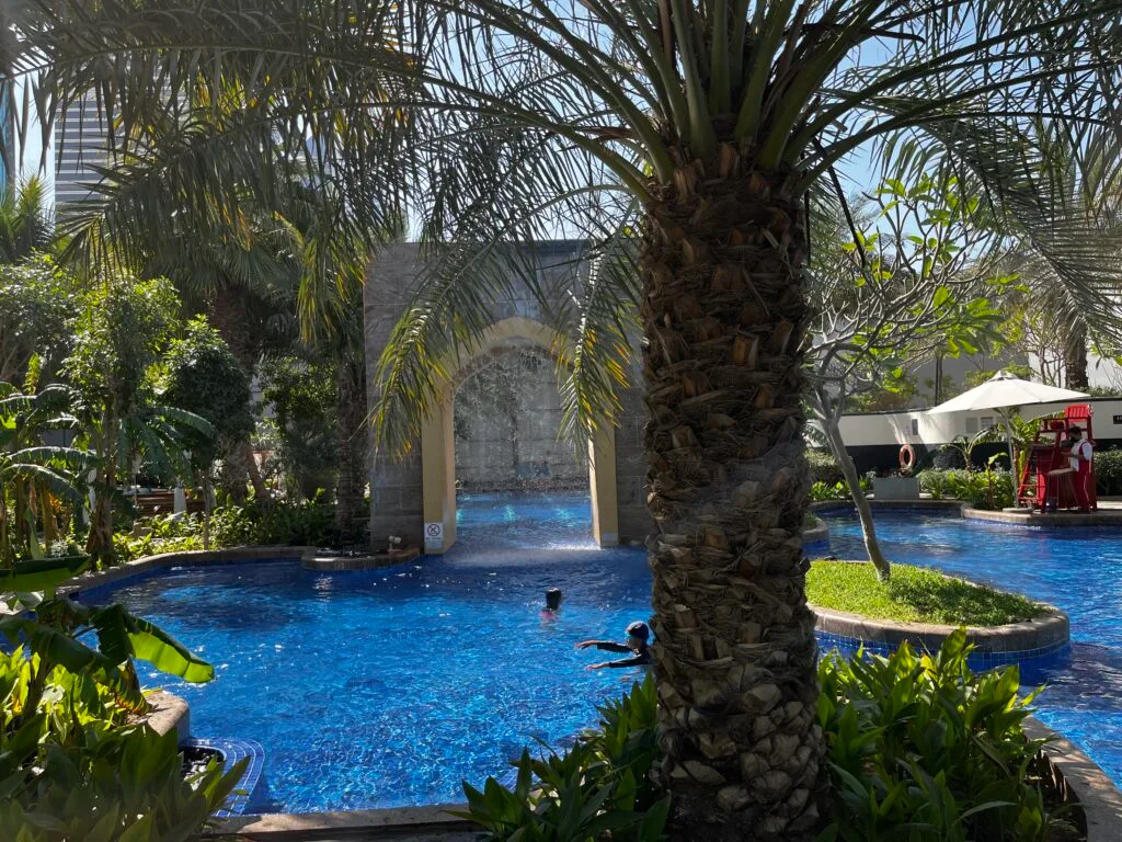 Außenbereich mit Pool und Palmen im Hotel Conrad Dubai