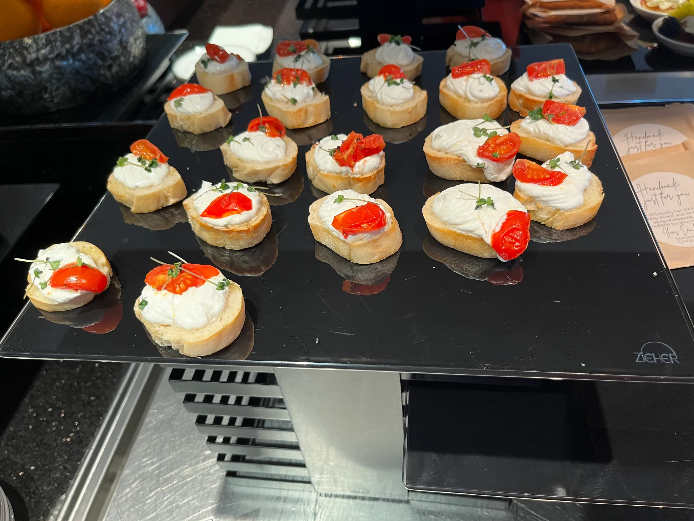 Kleine Brötchen mit Tomaten und Sahne auf Tablett