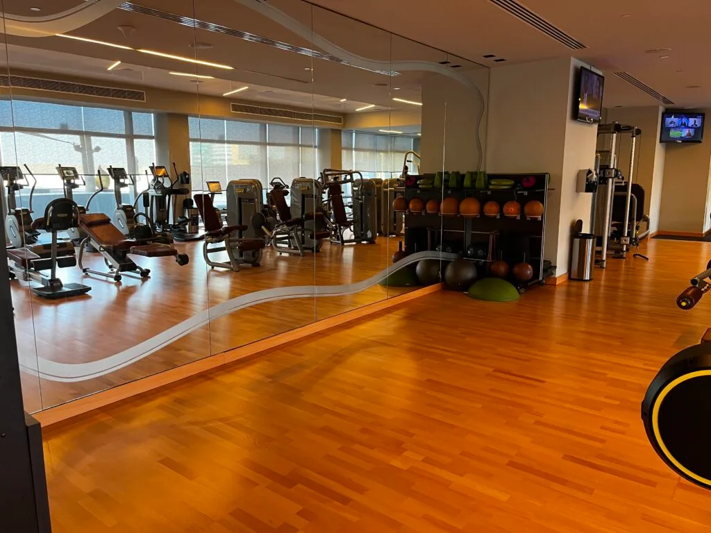 Fitnessraum mit Spiegeln und verschiedenen Trainingsgeräten